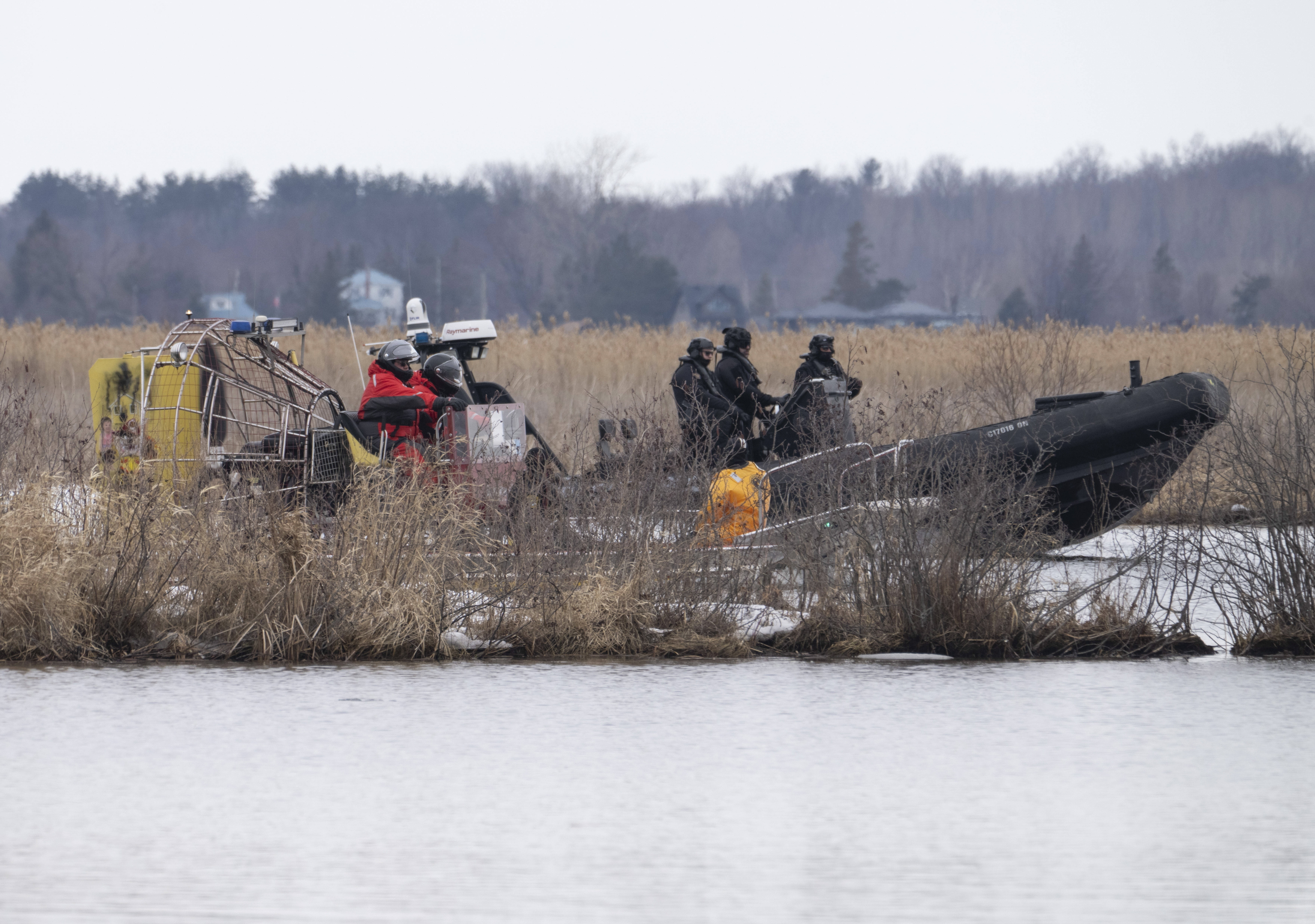 Socorristas buscan el viernes 31 de marzo de 2023 a víctimas que se ahogaron cuando intentaban cruzar hacia Estados Unidos por un río en Akwesasne, Québec, en Canadá. (Ryan Remiorz/The Canadian Press vía AP)