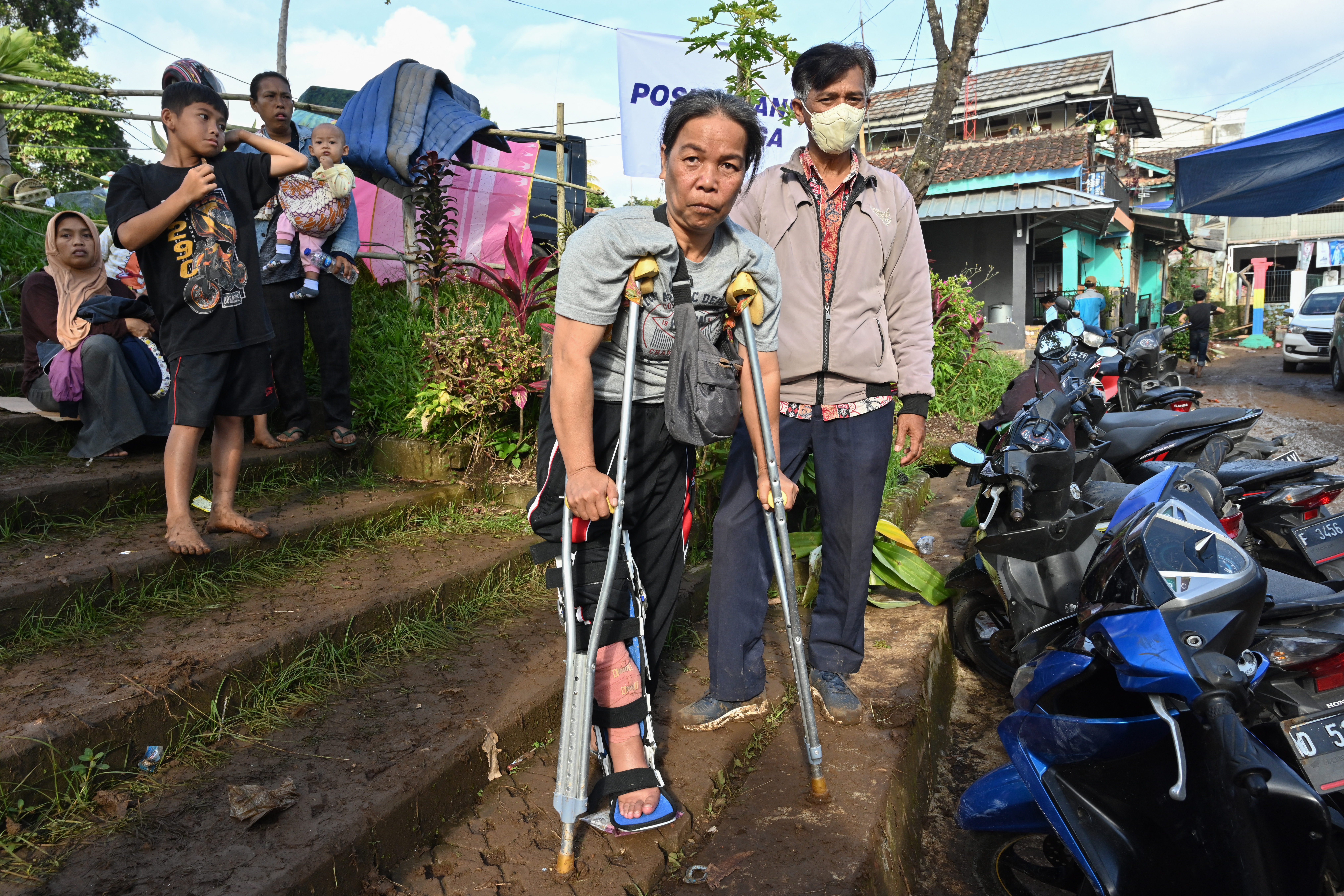 Una mujer herida con muletas frente a un refugio en Cugenang en Cianjur (ADEK BERRY / AFP)