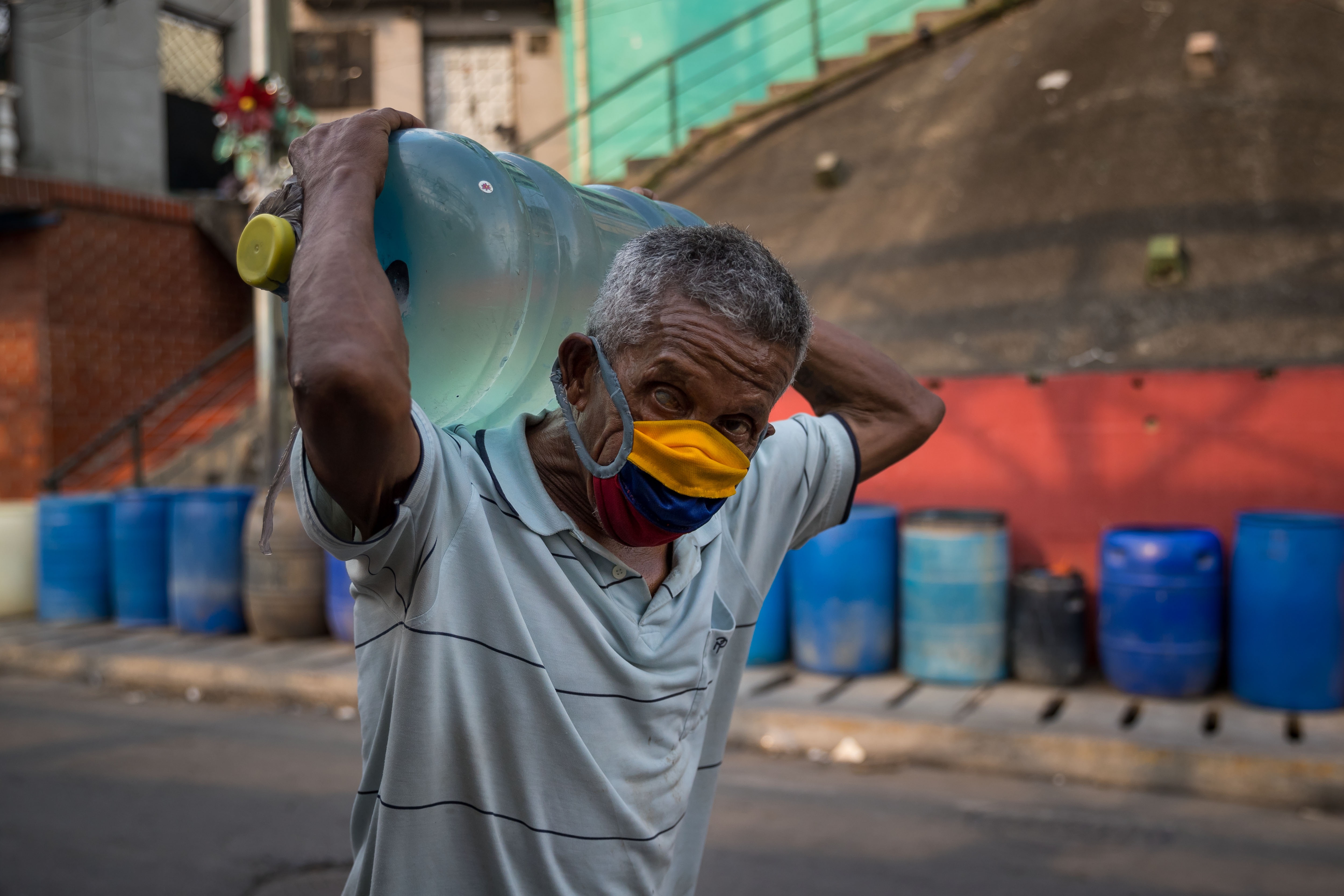 Fotografía de archivo, tomada en octubre de 2020, en la que se registró a un hombre al cargar un botellón de agua potable suministrado por un camión cisterna, en Caracas (Venezuela). EFE/Miguel Gutiérrez

