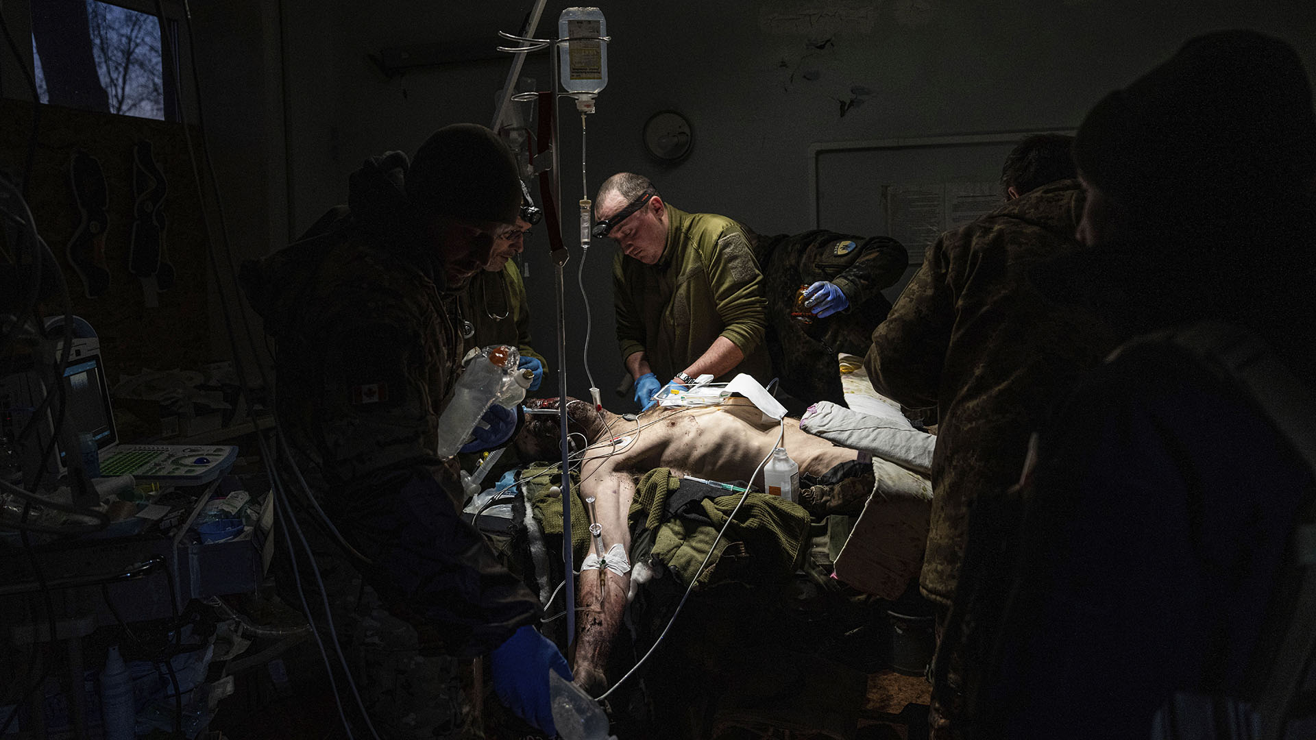 Ukrainian military medics treat their wounded comrade who was evacuated from the battlefield at the hospital in Donetsk Region, Ukraine, Monday, January 9, 2023. The serviceman did not survive.  (AP Photo/Evgeniy Maloletka)