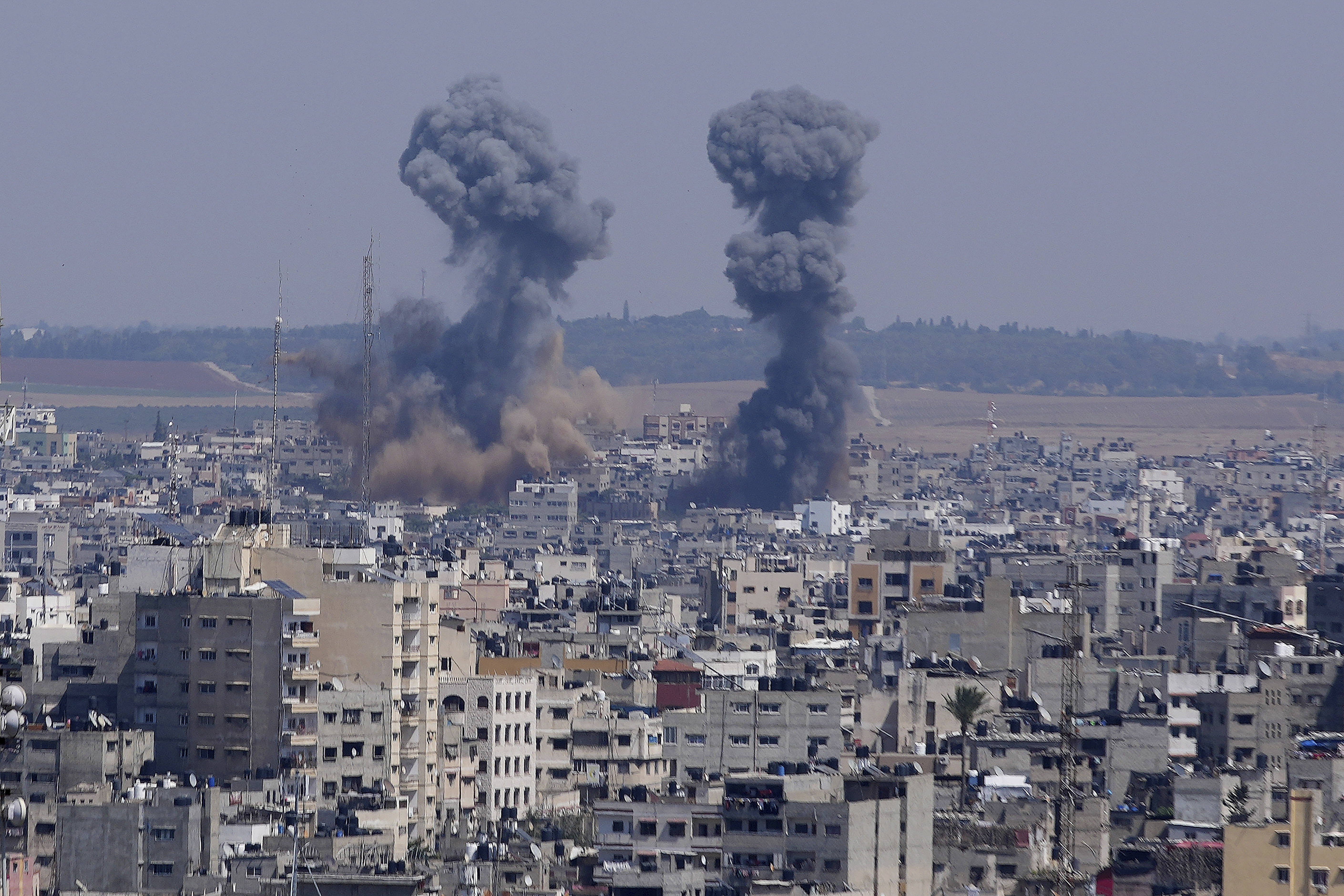 Columnas de humo se alzan entre unos edificios tras un ataque aéreo israelí, en Gaza, el miércoles 10 de mayo de 2023. (AP Foto/Adel Hana)