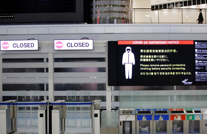 Imagen de un aviso sobre las medidas de seguridad por el COVID-19 junto a puertas de salida cerradas en el Aeropuerto Internacional Narita en el primer día de fronteras cerradas para evitar la propagación de la nueva variante ómicron del coronavirus, en Narita, al este de Tokio, Japón. 30 de noviembre, 2021. REUTERS/Kim Kyung-Hoon