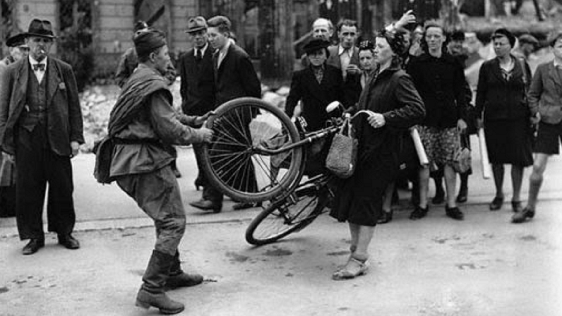 Un soldádo soviético le roba a una mujer alemana durante la opcupación