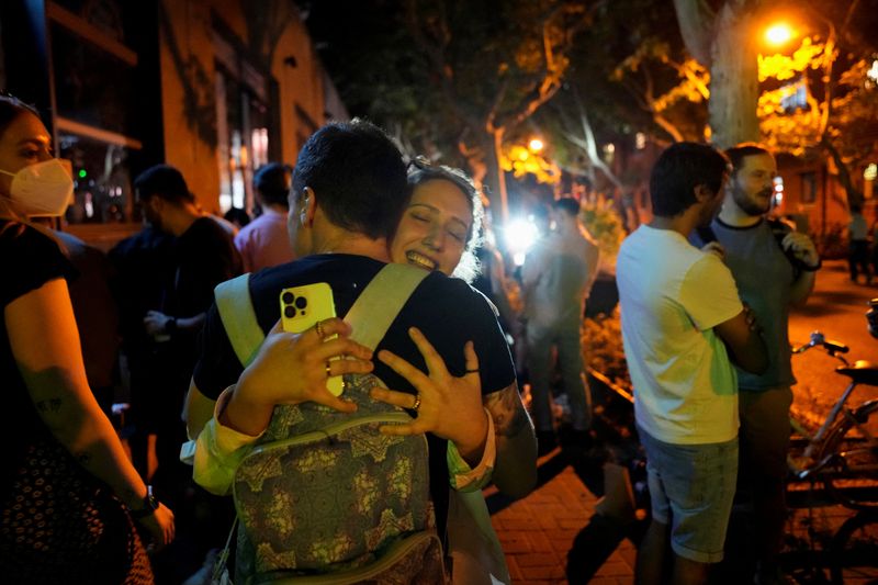 La gente se abraza en una calle (REUTERS/Aly Song)