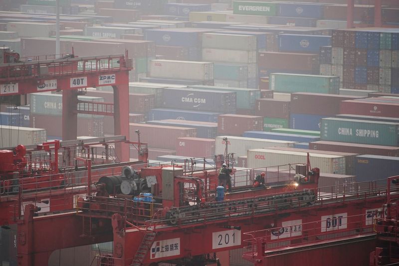 FOTO DE ARCHIVO: Trabajadores en una grúa junto a contenedores de carga en el puerto de gran calado de Yangshan, en Shanghái, China, el 13 de enero de 2022. REUTERS/Aly Song