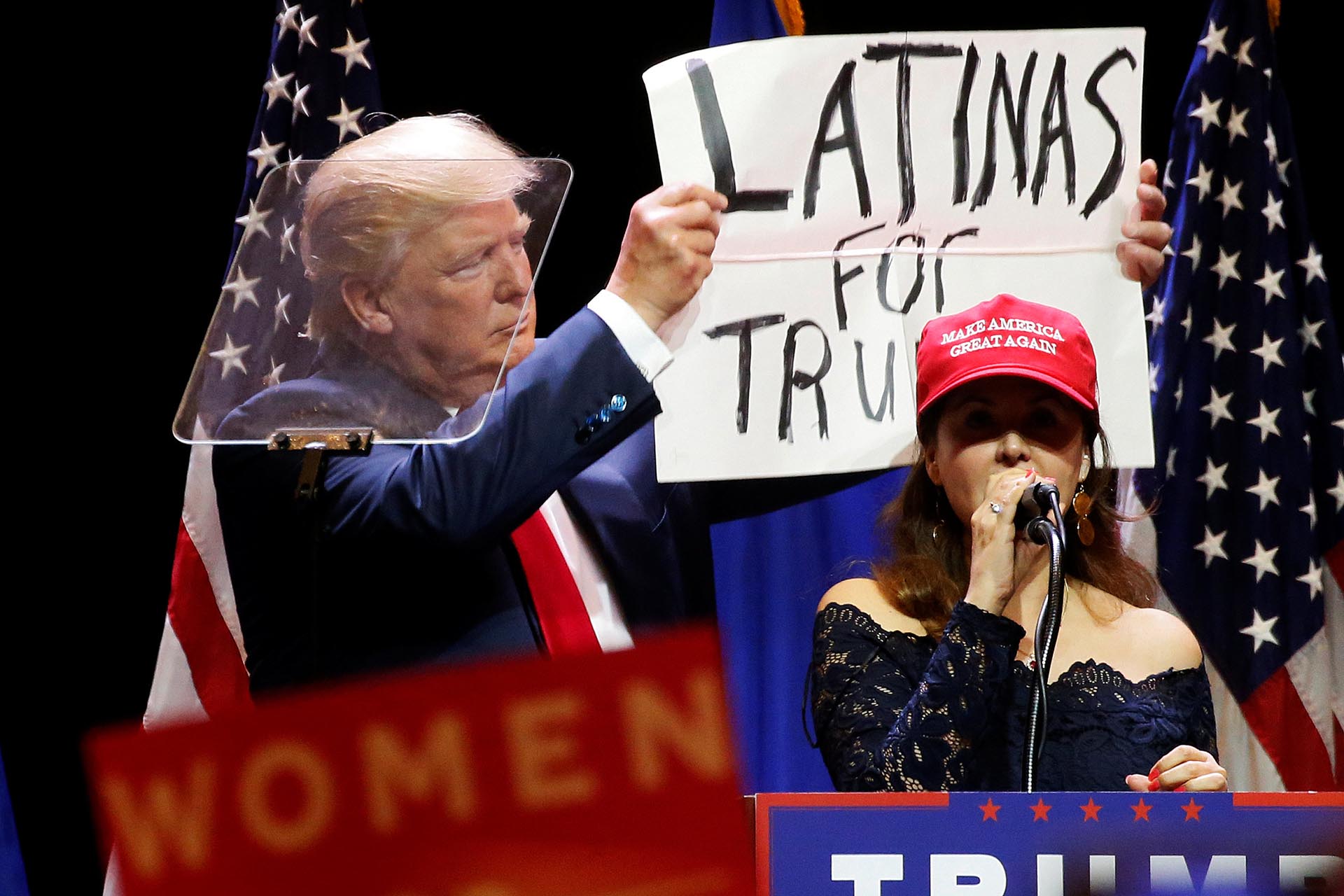 Trump mostrando un cartel de apoyo de las mujeres hispanas durante un acto en Las Vegas. REUTERS/Carlo Allegri     