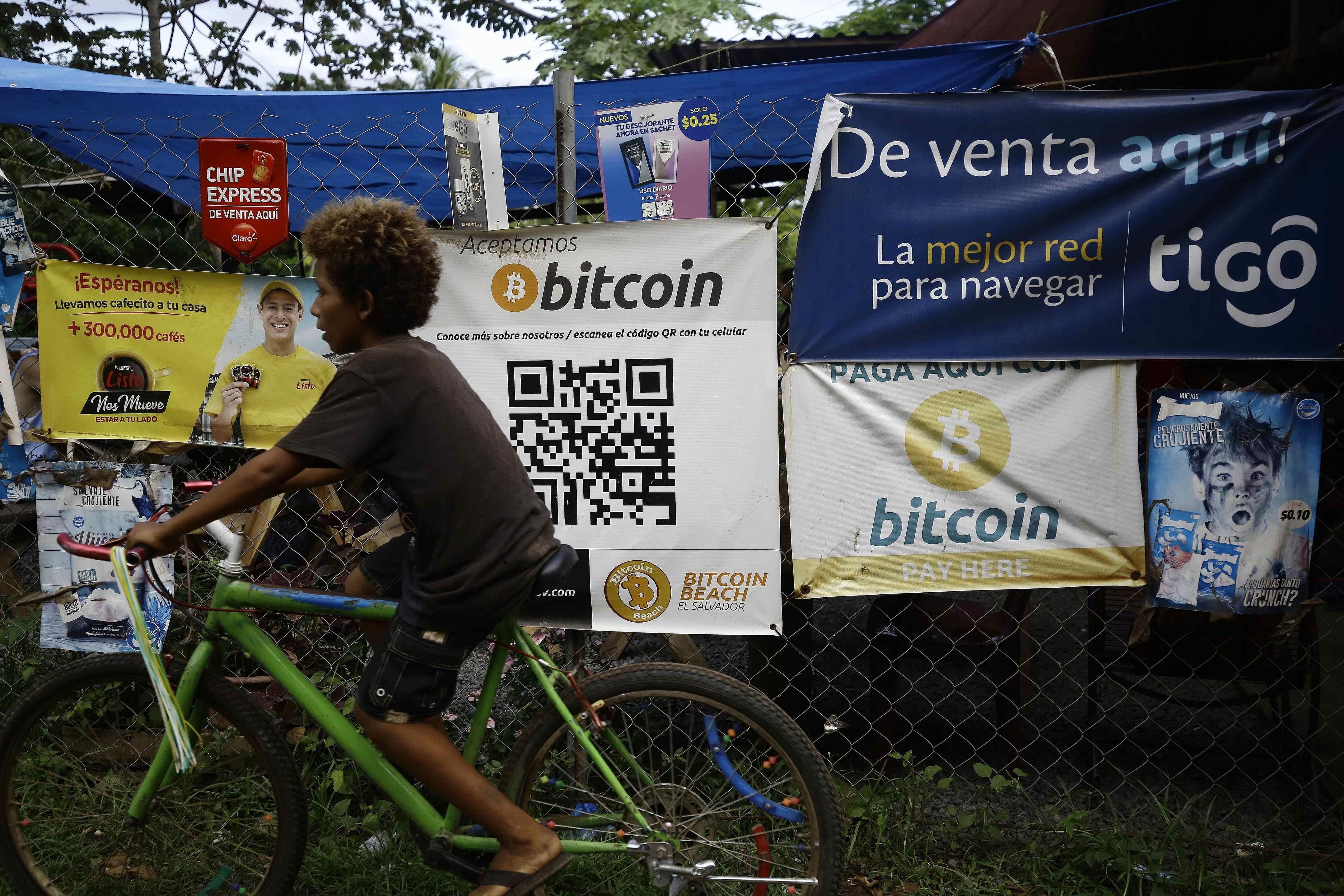 Fotografía de carteles que ofrecen bitcoin como forma de pago cerca a la playa El Zonte, en Chiltiupan, El Salvador. (EFE/ Miguel Lemus)