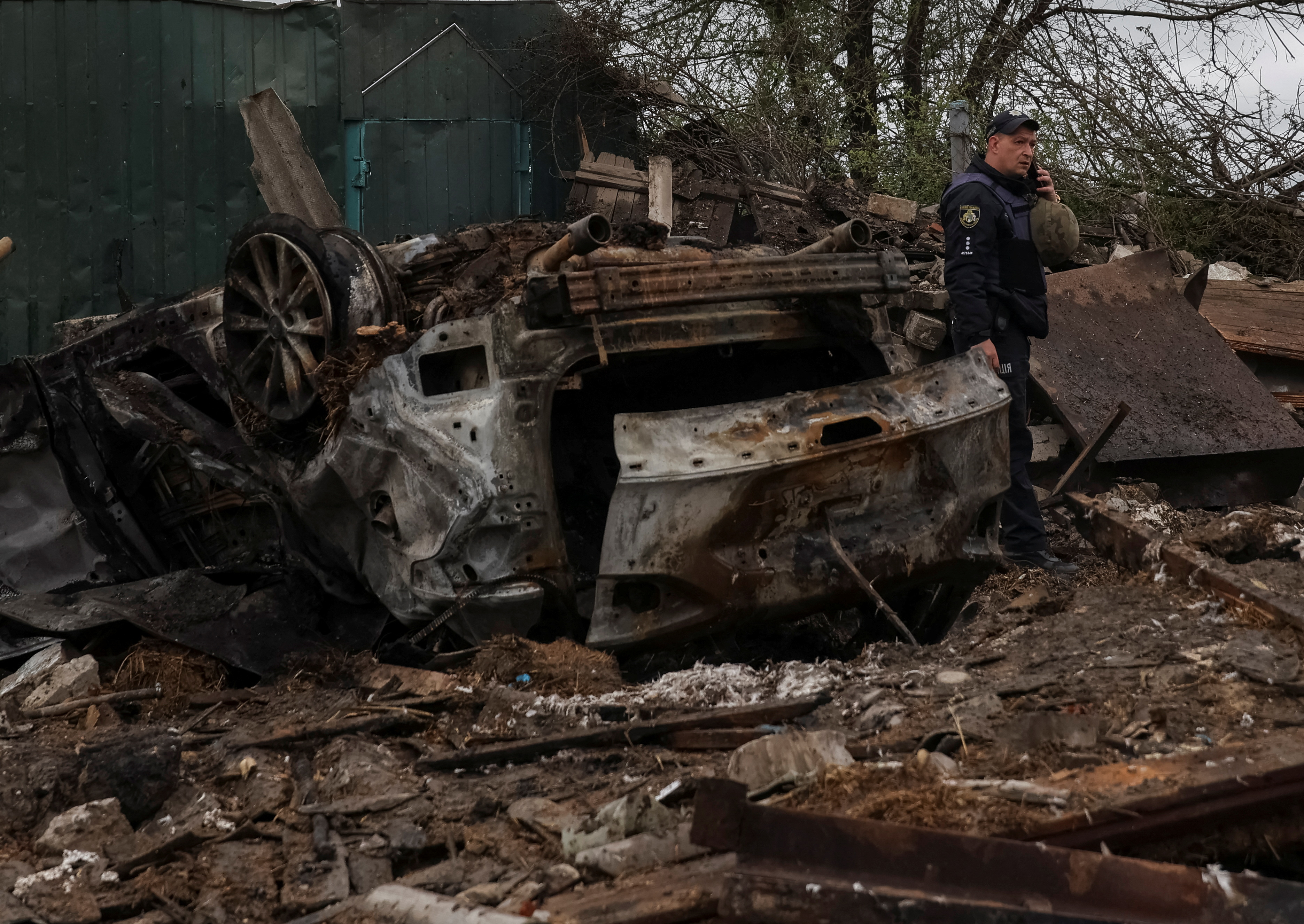 Un oficial de policía es visto en el sitio de un área residencial afectada por un ataque militar ruso. REUTERS/Sofiia Gatilova