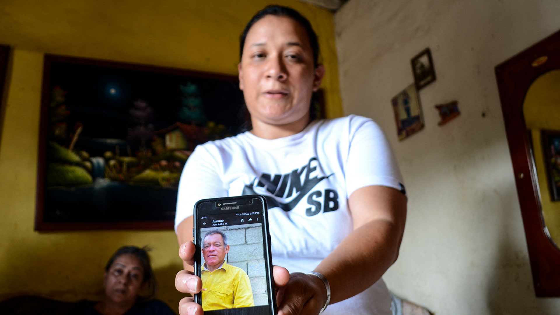 Joselyn Oropeza muestra en su celular una foto de su tío Oswaldo Oviedo, una de las nueve personas que fallecieron tras ingerir alcohol adulterado (Néstor VIVAS/AFP)