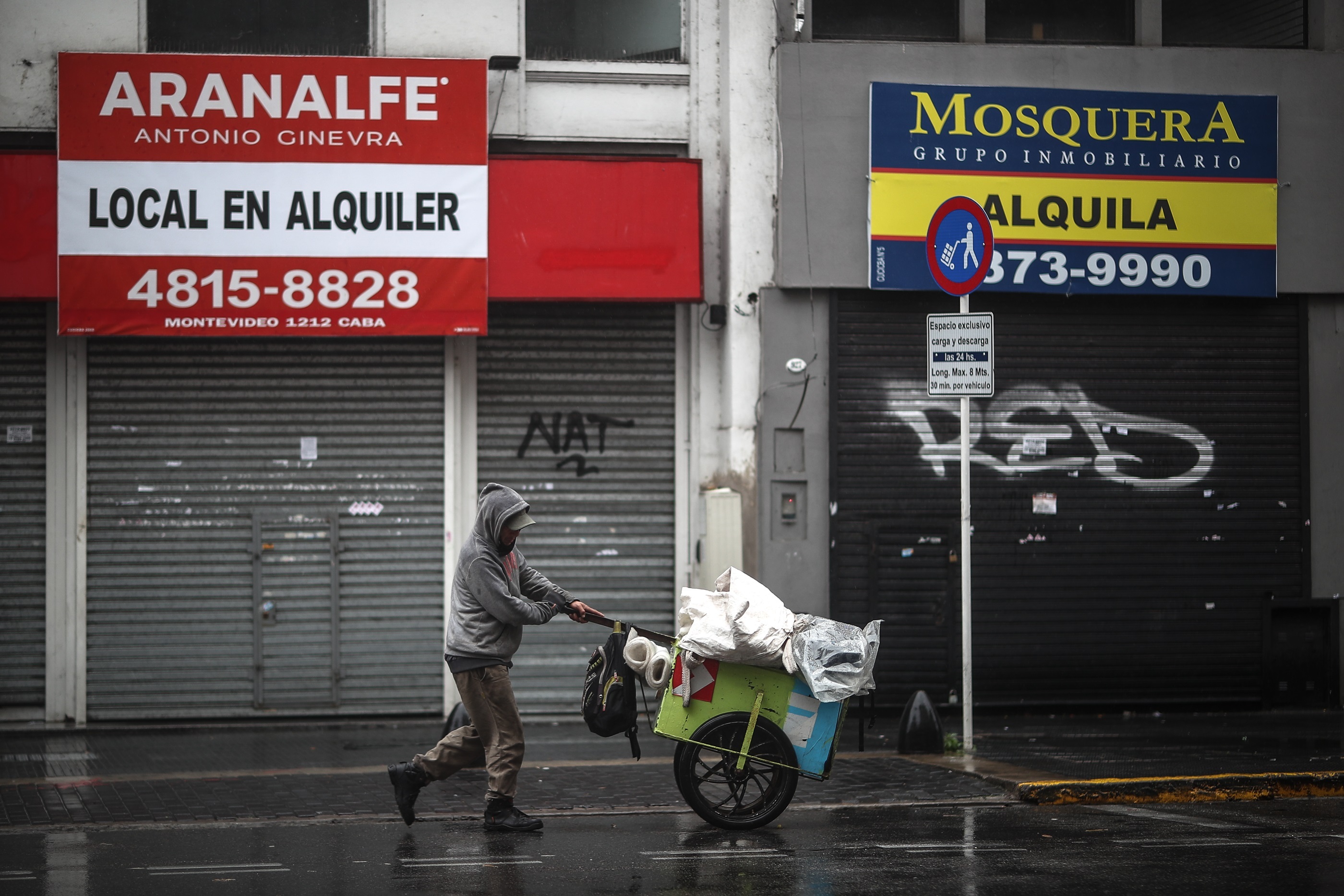 Una persona camina entre comercios cerrados por una calle en la Ciudad de Buenos Aires (Foto: EFE)
