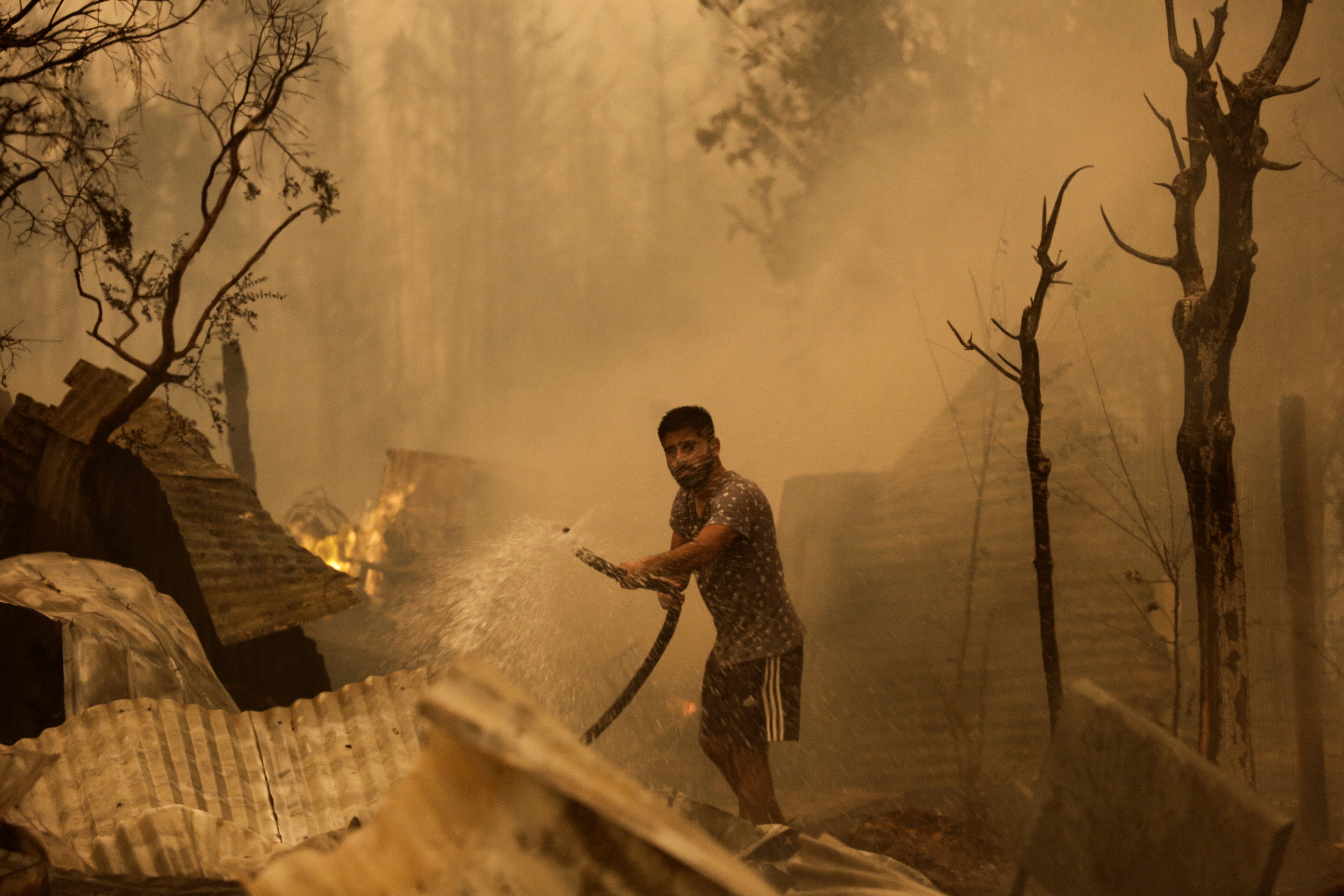 Un residente intenta apagar el fuego durante un incendio forestal en Santa Juana, cerca de Concepción, Chile, 3 de febrero de 2023. REUTERS/Juan González