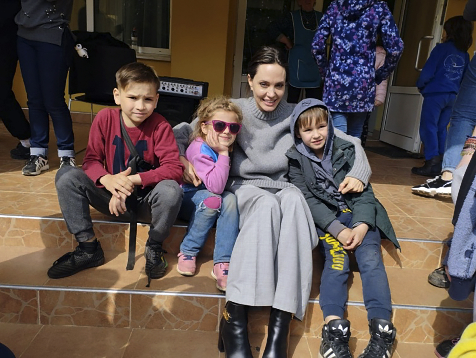 Angelina Jolie, estrella de cine de Hollywood y embajadora de buena voluntad del ACNUR, posa para una foto con niños en Lviv, Ucrania, el sábado 30 de abril de 2022 (Maksym Kozutsky/Ayuntamiento de Lviv vía AP)