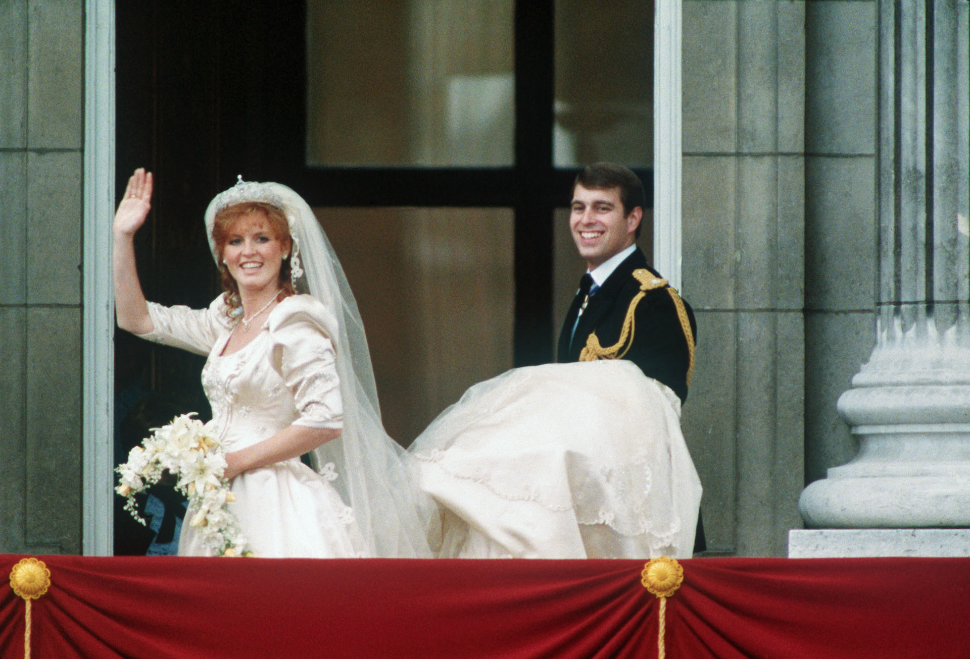 (lmagen de archivo) El Duque de York, Andrés, lleva la cola de la Duquesa Sarah Ferguson mientras saluda desde el balcón el día de su boda.