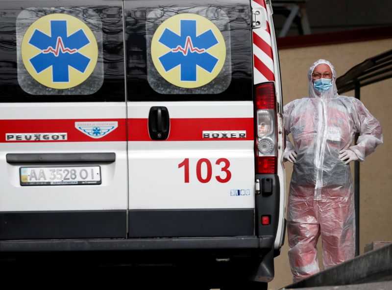 FOTO DE ARCHIVO: Un trabajador de la salud se encuentra cerca de una ambulancia que transporta a un paciente con COVID-19, mientras esperan en la cola de un hospital para las personas infectadas con la enfermedad del coronavirus en Kiev, Ucrania 18 de octubre de 2021.  REUTERS/Gleb Garanich
