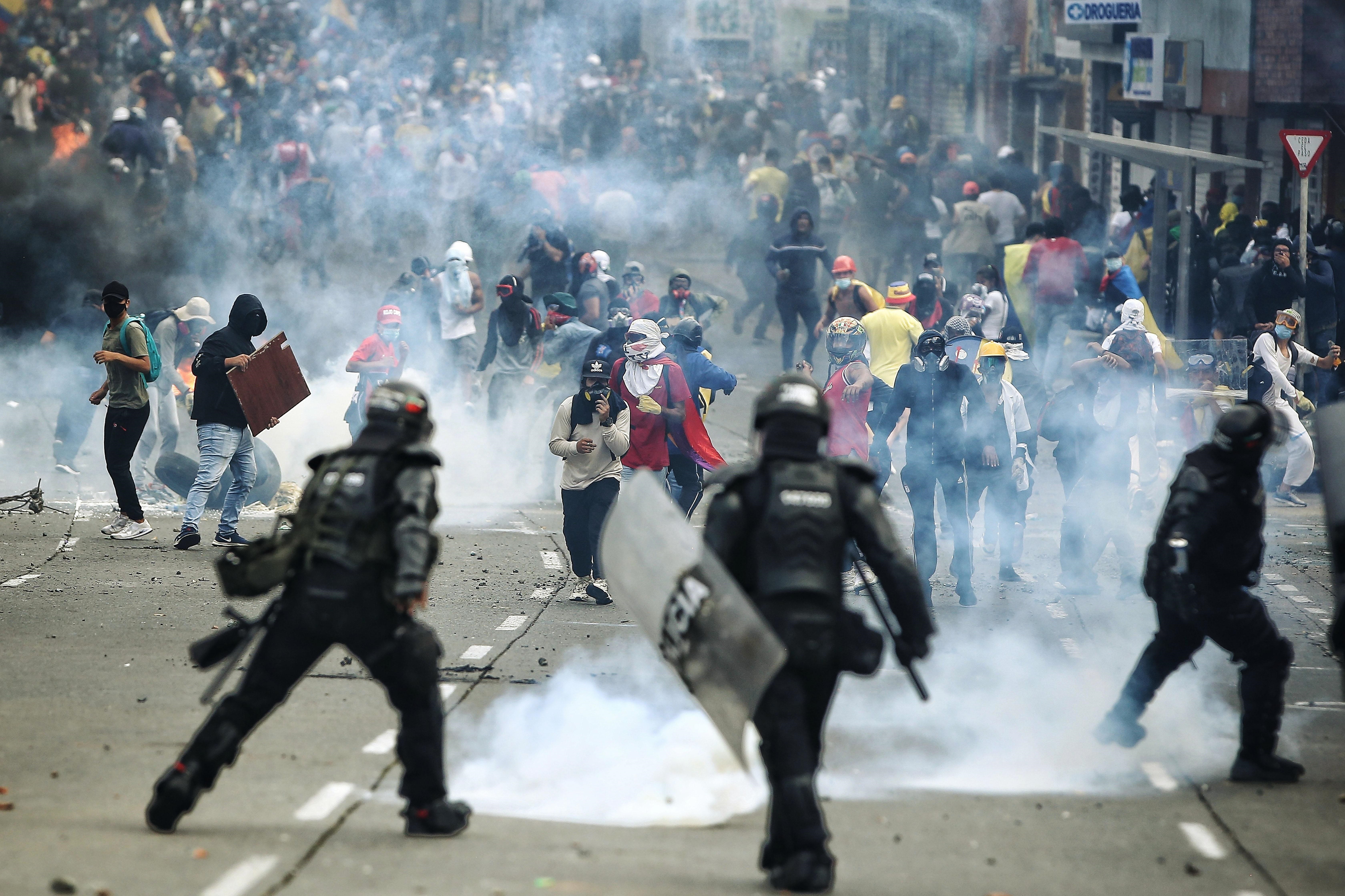 Manifestantes se enfrentan a integrantes del Escuadrón Móvil Antidisturbios (ESMAD) de la Policía colombiana, en la Loma de la Cruz en Cali (EFE/ Pablo Rodríguez)