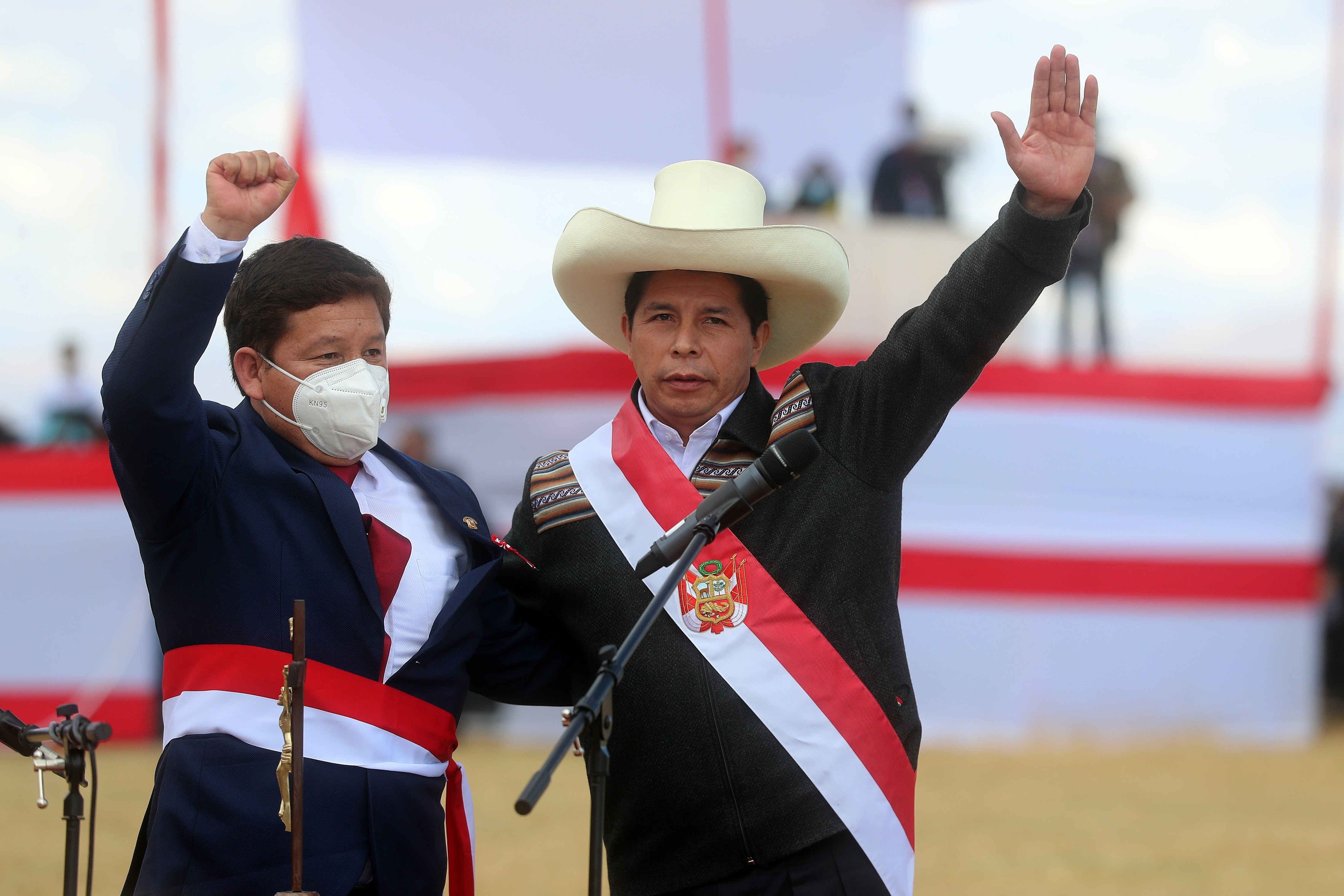 El recién investido presidente peruano Pedro Castillo (d) mientras celebra con Guido Bellido luego de elegirlo como primer ministro de su Gobierno, durante una ceremonia simbólica de juramentación