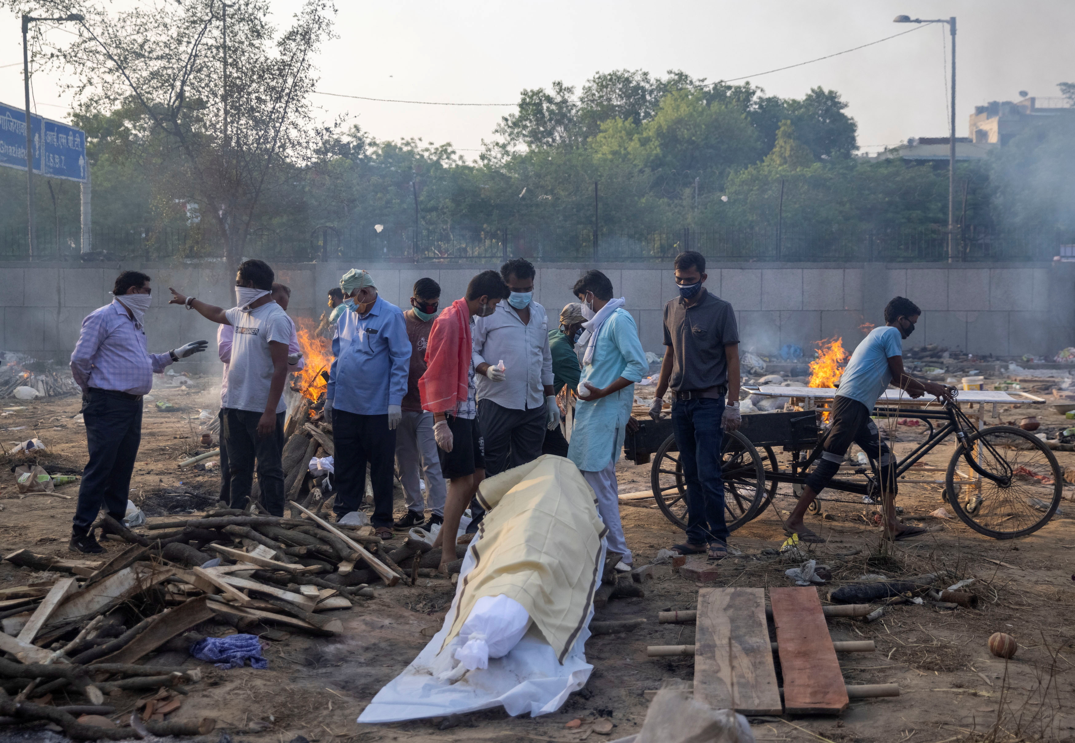 Familiares se preparan para incinerar el cuerpo de una persona que murió debido a la enfermedad del COVID-19 en un crematorio en Nueva Delhi, India (Reuters)