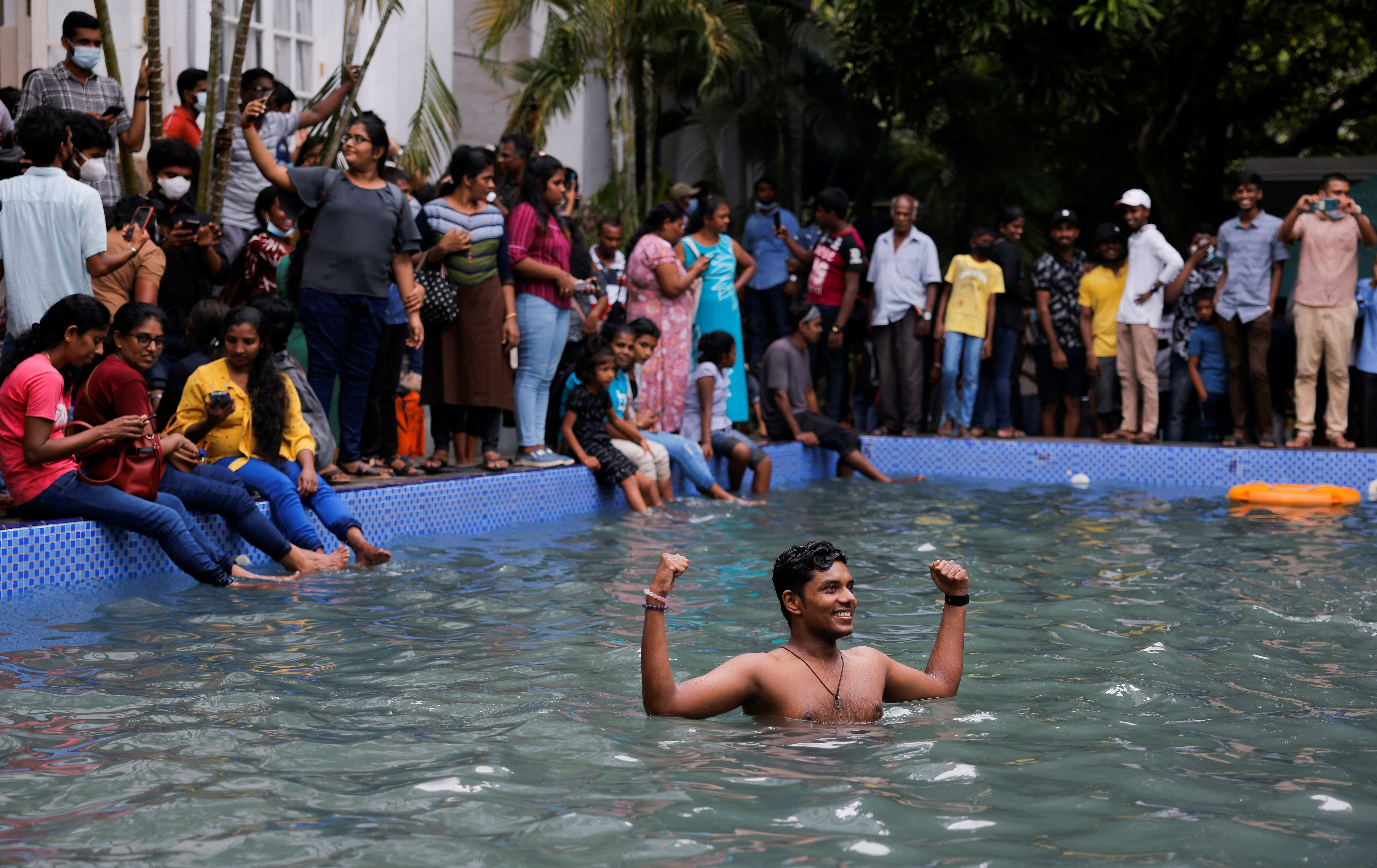 Un hombre se encuentra en la piscina mientras la gente visita la casa del presidente el día después de que los manifestantes ingresaran al edificio (REUTERS/Dinuka Liyanawatte)