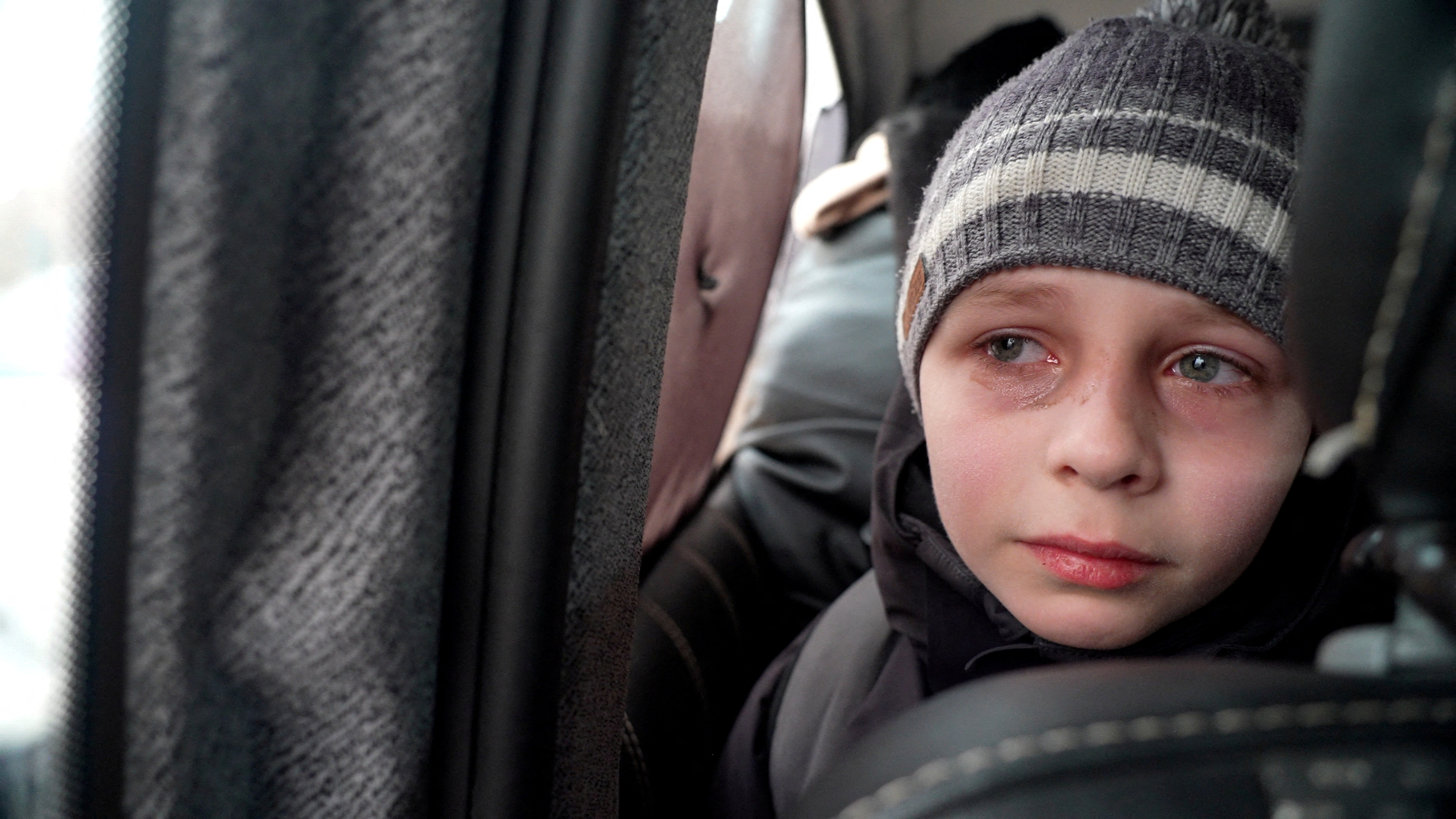 Mark Goncharuk, un niño de Kiev, reacciona mientras habla sobre dejar atrás a su padre mientras viaja con el resto de su familia hacia la frontera (REUTERS/Natalie Thomas)