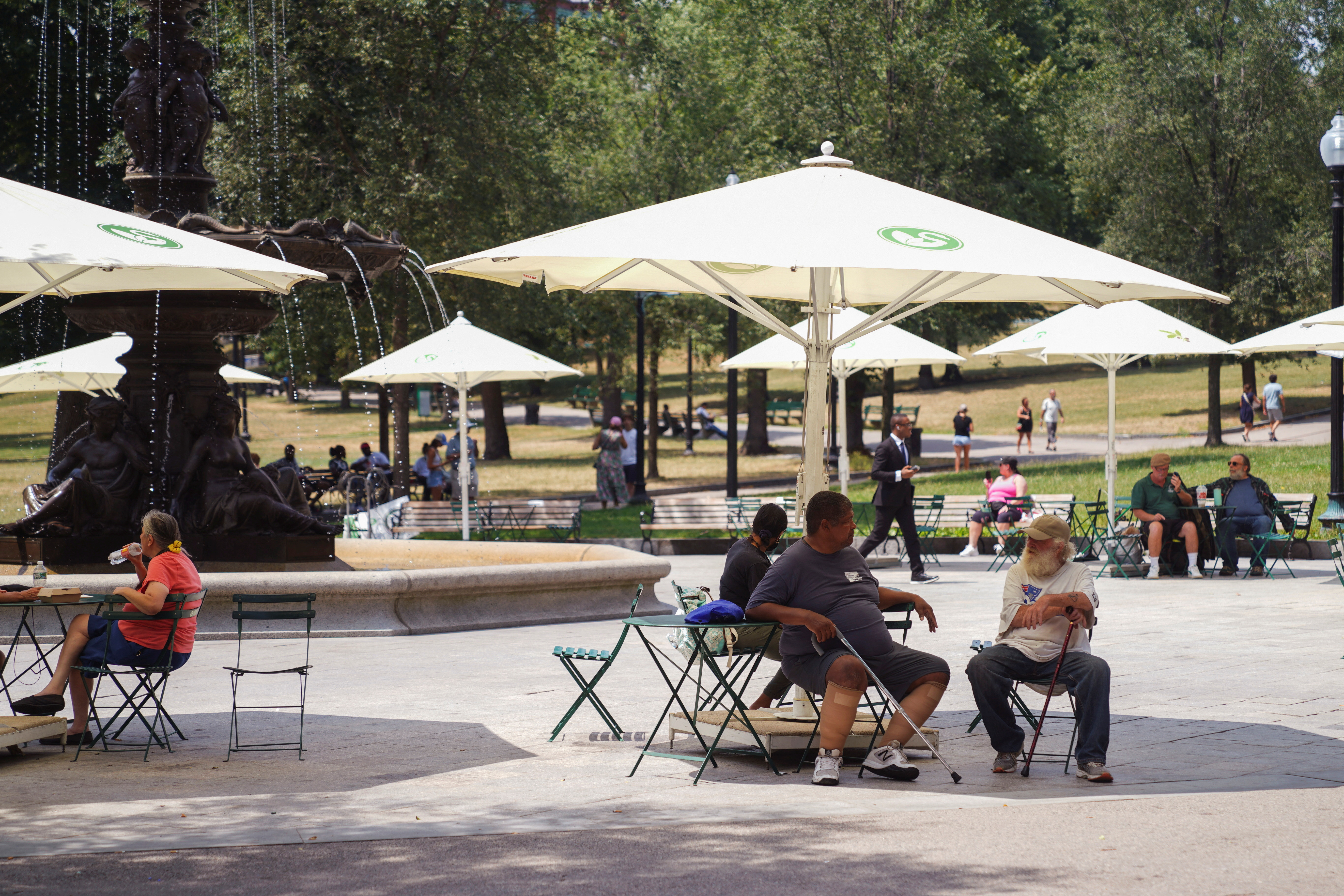 Personas sentadas bajo sombrillas en un parque durante la ola de calor en Boston, Massachusetts, Estados Unidos, el 21 de julio de 2022 (REUTERS/Allison Dinner)