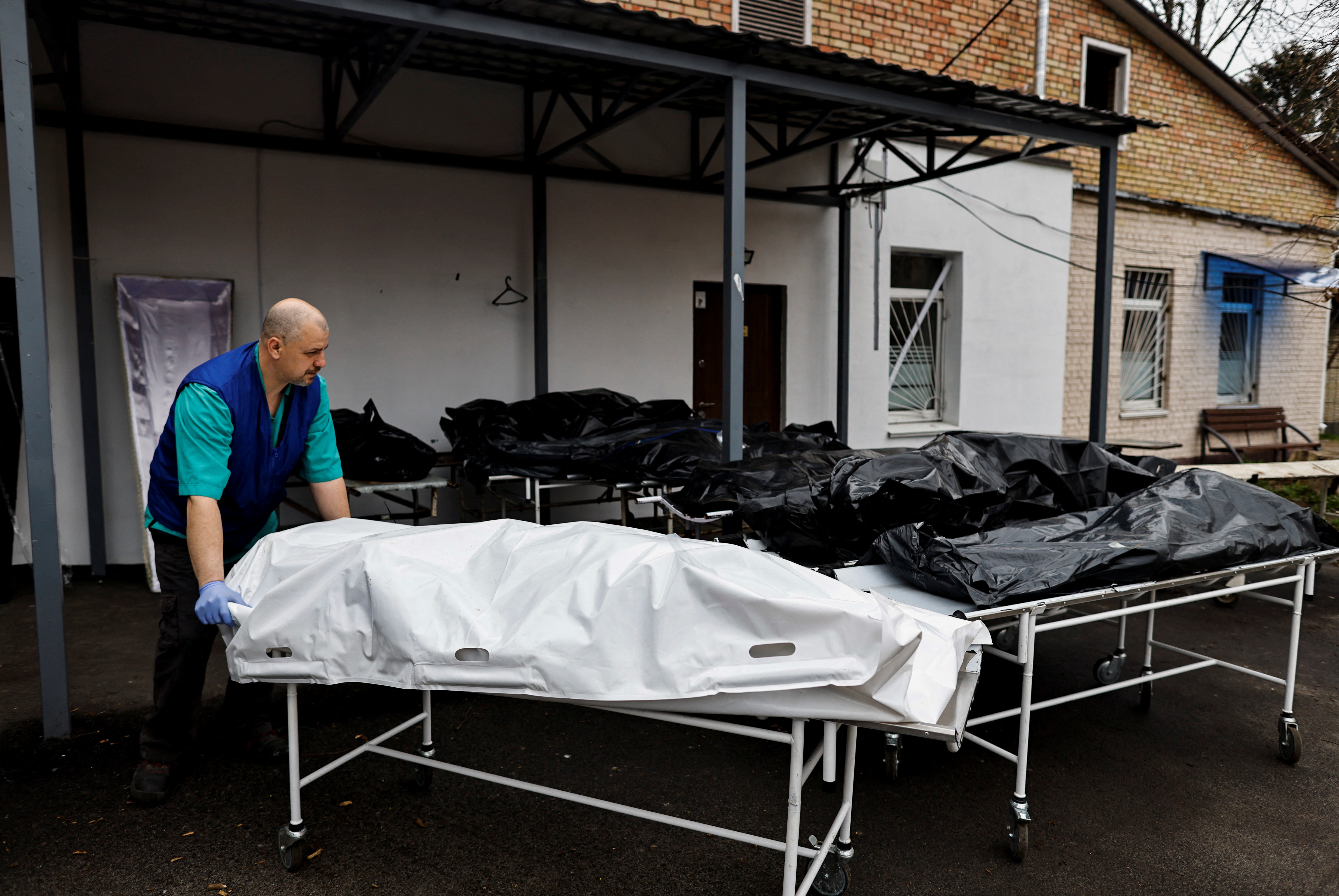 Los cuerpos que esperan ser identificados por sus familias se ven fuera de la morgue en medio de la invasión rusa de Ucrania, en Bucha, región de Kiev, Ucrania, 20 de abril de 2022. (REUTERS/Zohra Bensemra)