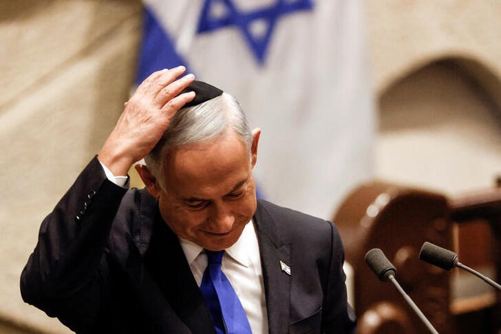 Israeli Prime Minister-designate Benjamin Netanyahu adjusts his kippah after speaking at a special session of Parliament where he swore the new government in Jerusalem.  December 29, 2022. REUTERS/Amir Cohen/Paul