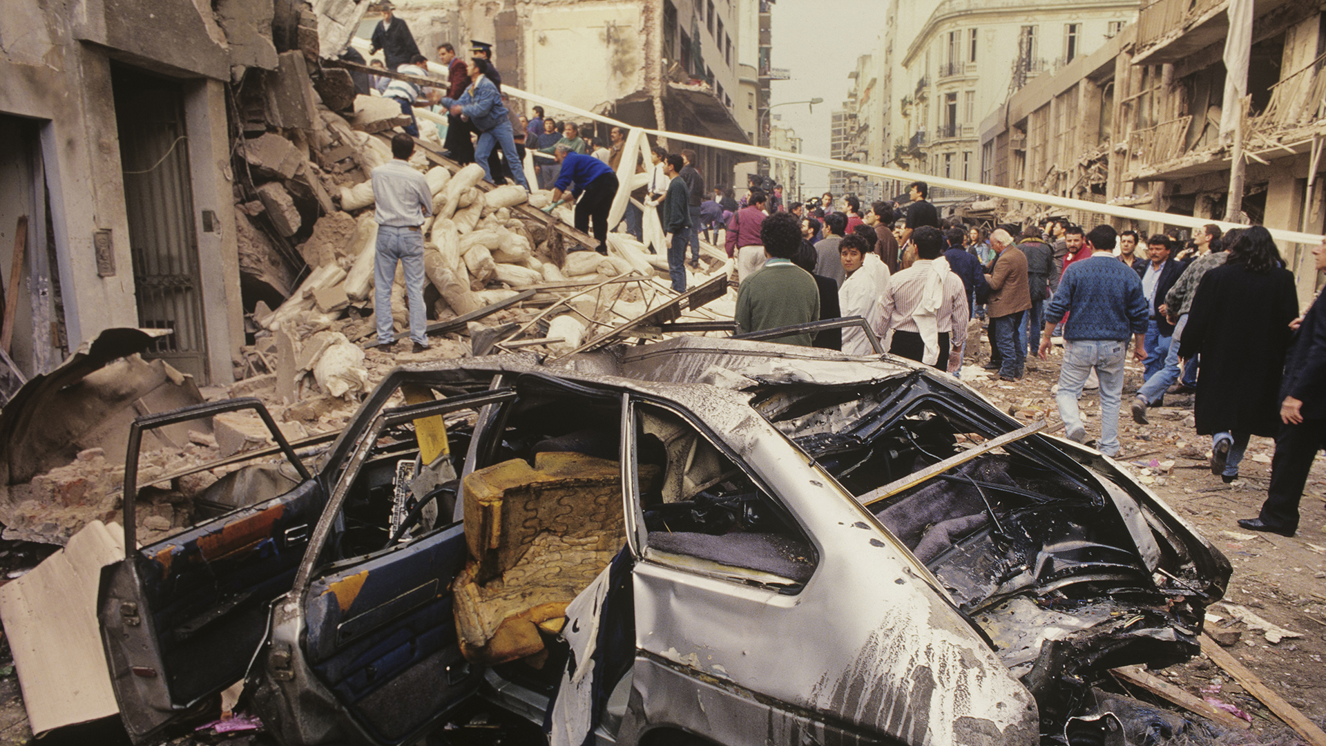 “Esta imagen da un poco de magnitud del atentado. Fue una fotografía muy usada por los medios porque el primer plano del coche destruido genera muchas lecturas” (Julio Menajovsky) 