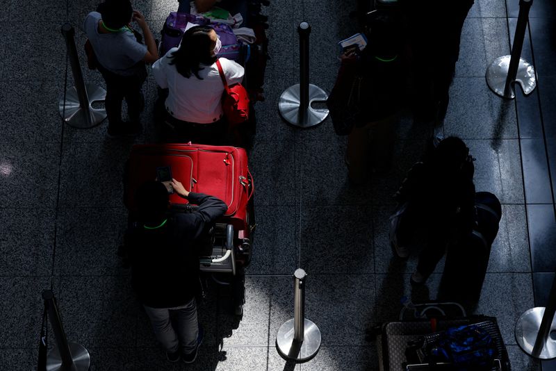 FOTO DE ARCHIVO: Los viajeros hacen cola para el autobús de enlace a los hoteles en cuarentena en el Aeropuerto Internacional de Hong Kong, en medio de la pandemia de la enfermedad por coronavirus (COVID-19), en Hong Kong, China, el 1 de junio de 2022. REUTERS/Tyrone Siu/Foto de archivo