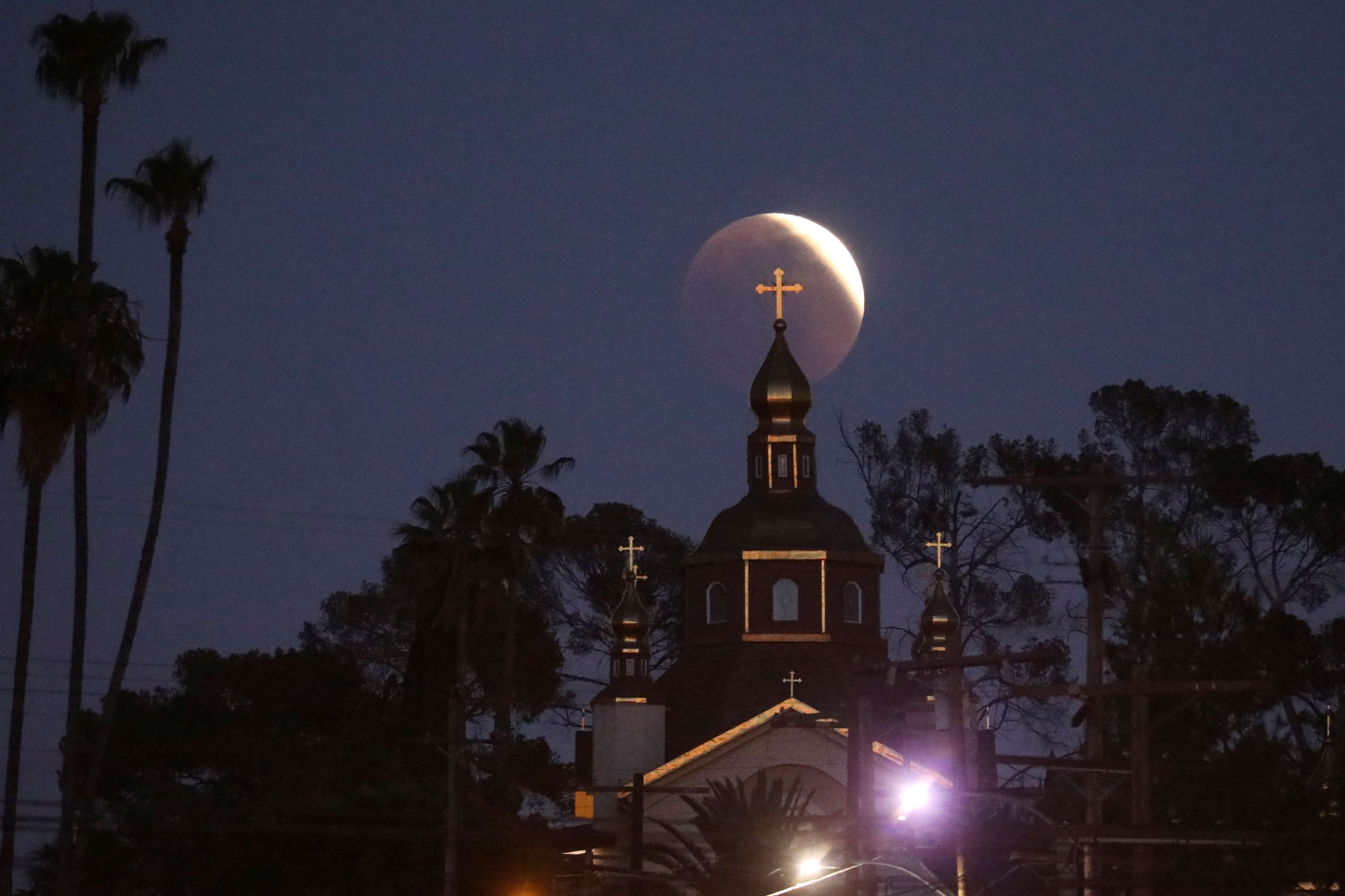 La Iglesia Ortodoxa de San Andrés se ve mientras la Luna se mueve a través de la sombra de la tierra en Los Ángeles, California (REUTERS/David Swanson)