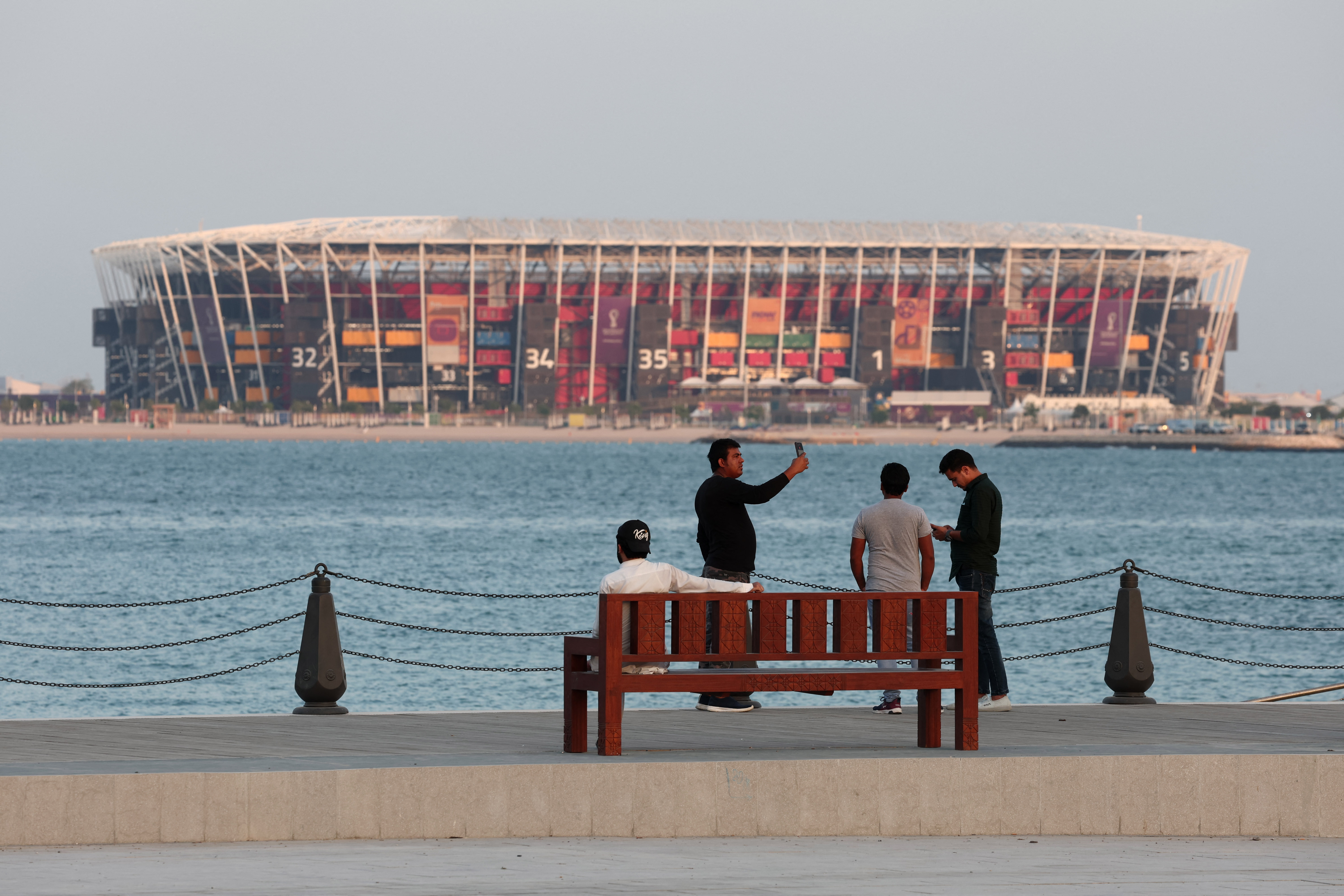 Soccer Football - FIFA World Cup Qatar 2022 Preview - Doha, Qatar - November 14, 2022 A man takes a selfie in front of Stadium 974 in Doha REUTERS/Marko Djurica