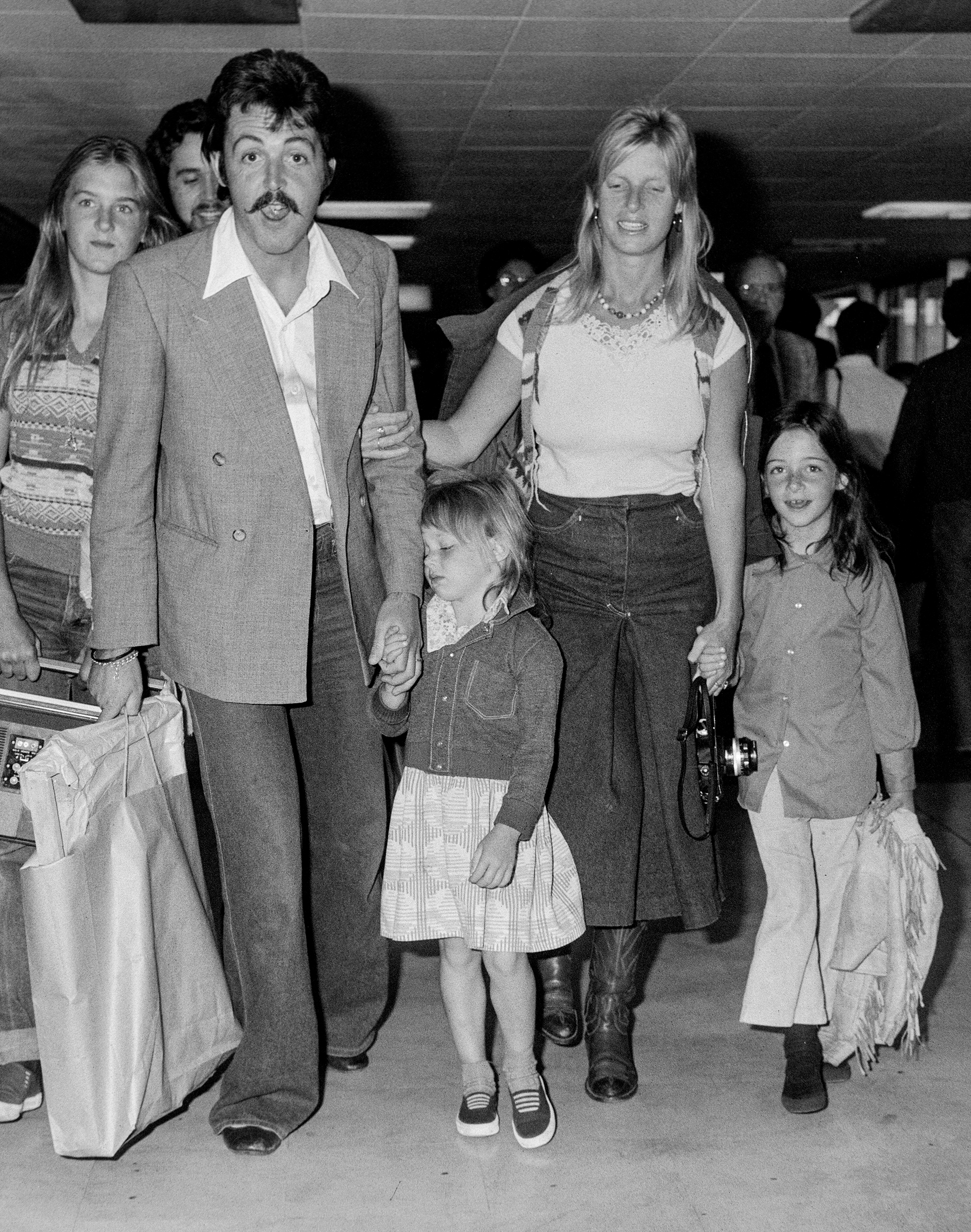 Paul and Linda McCartney y su familia en el Aeropuerto de Londres en 1976, cuatro años de la detención de McCartney por posesión de drogas. 