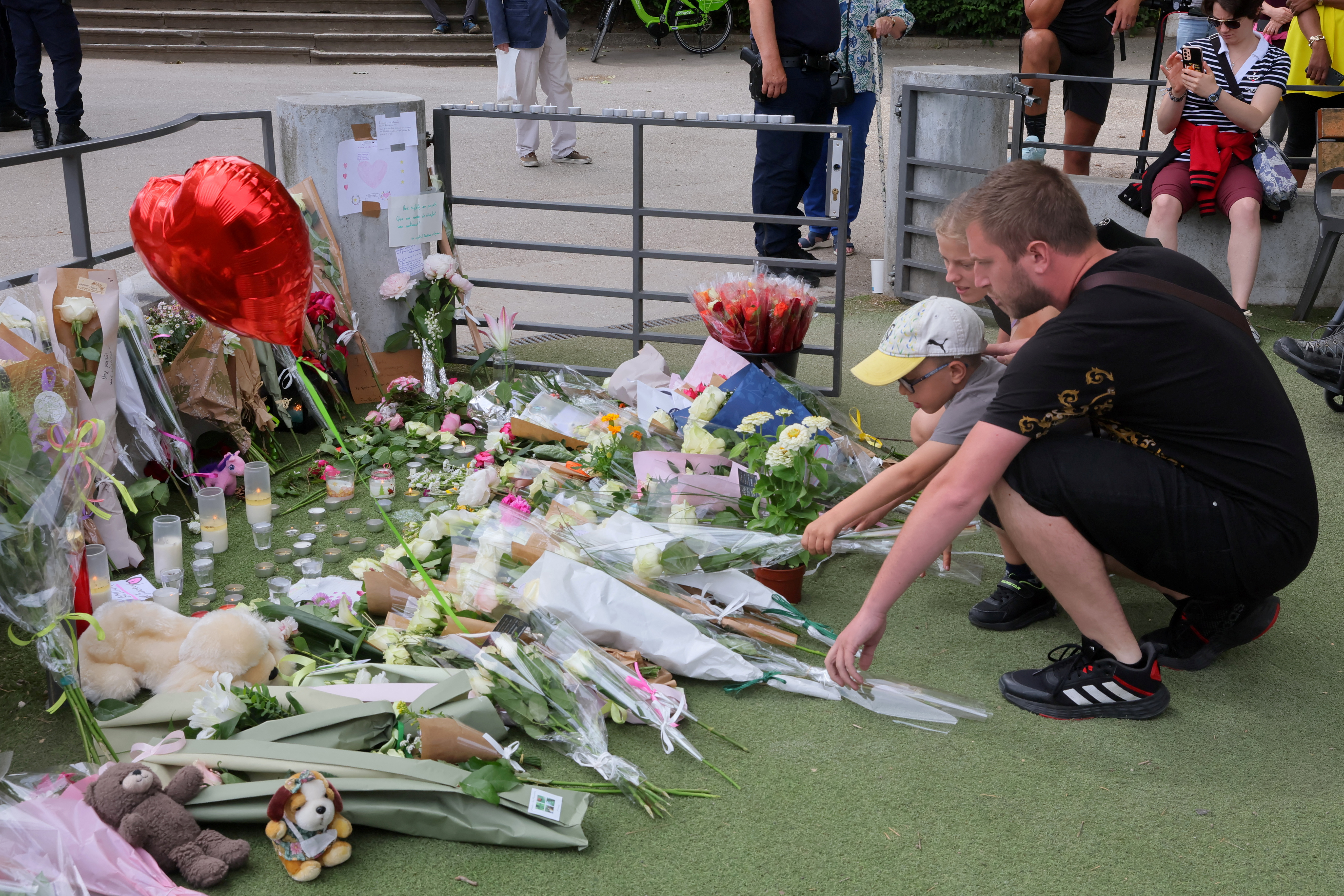 La gente rinde respeto frente a mensajes y ofrendas florales en el parque infantil el día después de que varios niños y adultos resultaran heridos en un ataque con cuchillo en el parque Le Paquier cerca del lago en Annecy, en los Alpes franceses, Francia, 9 de junio de 2023. REUTERS/Denis Balibouse