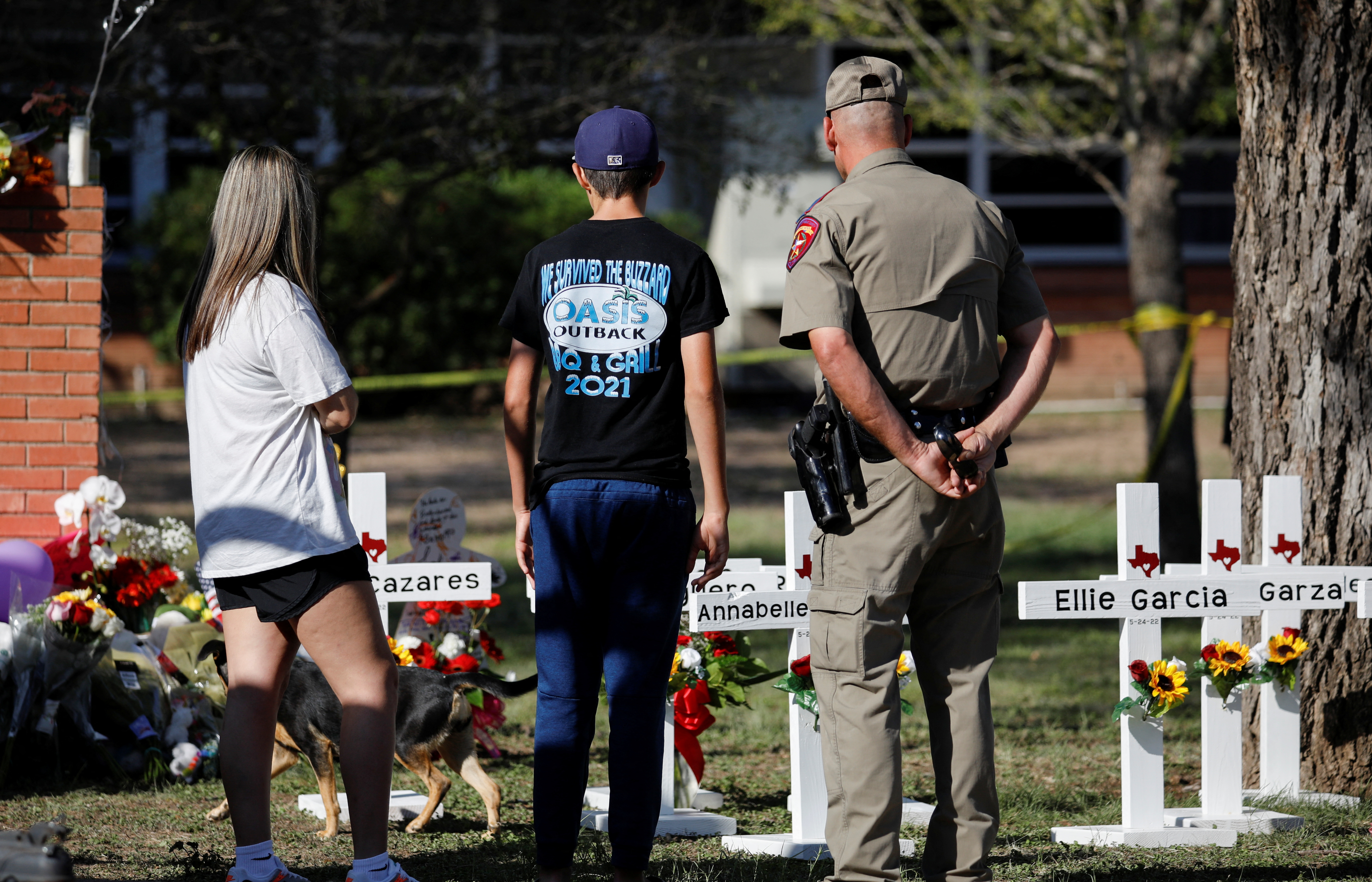 Gente mira las cruces con los nombre de los niños asesinados en la masacre en Texas (REUTERS/Marco Bello)