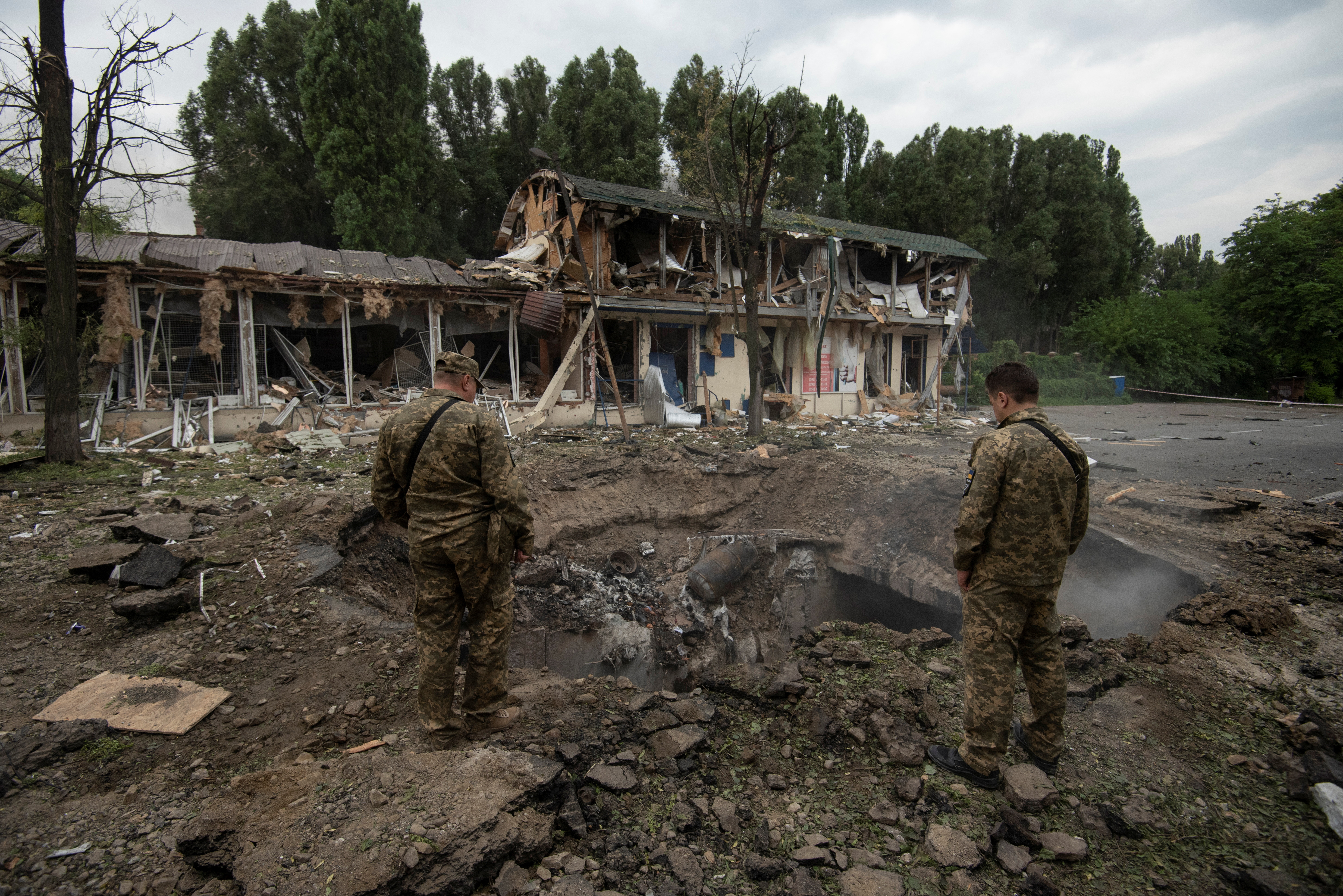 Miembros del servicio ucraniano inspeccionan un cráter dejado por un ataque de misiles rusos, mientras continúa el ataque de Rusia a Ucrania, en Dnipro, Ucrania el 16 de julio de 2022.  (REUTERS/Mykola Synelnykov)