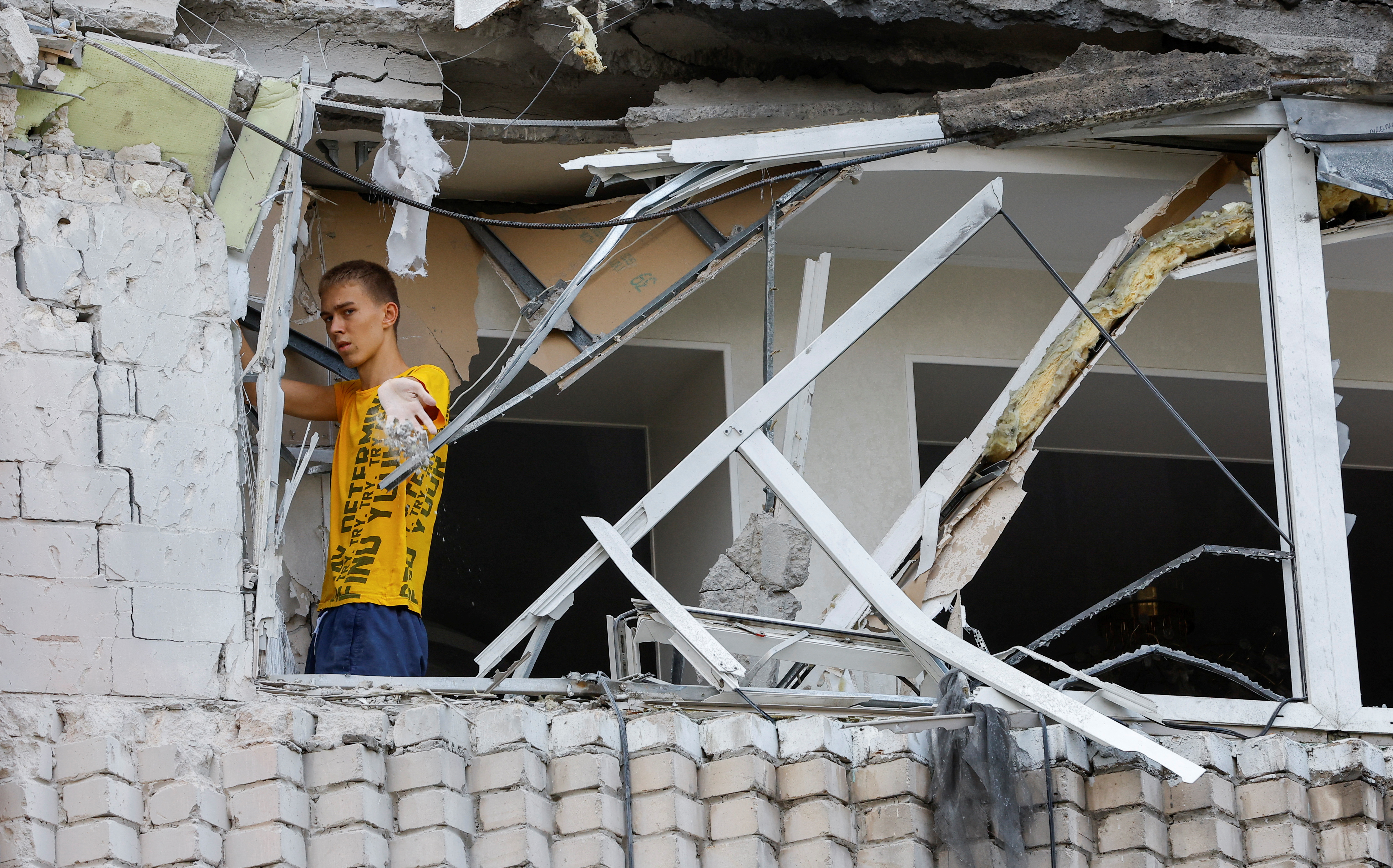 Un residente local retira los escombros dentro de un bloque de apartamentos de varias plantas dañado por los bombardeos durante el conflicto entre Ucrania y Rusia en la ciudad de Enerhodar, controlada por Rusia, en la región de Zaporizhzhia (REUTERS/Alexander Ermochenko)