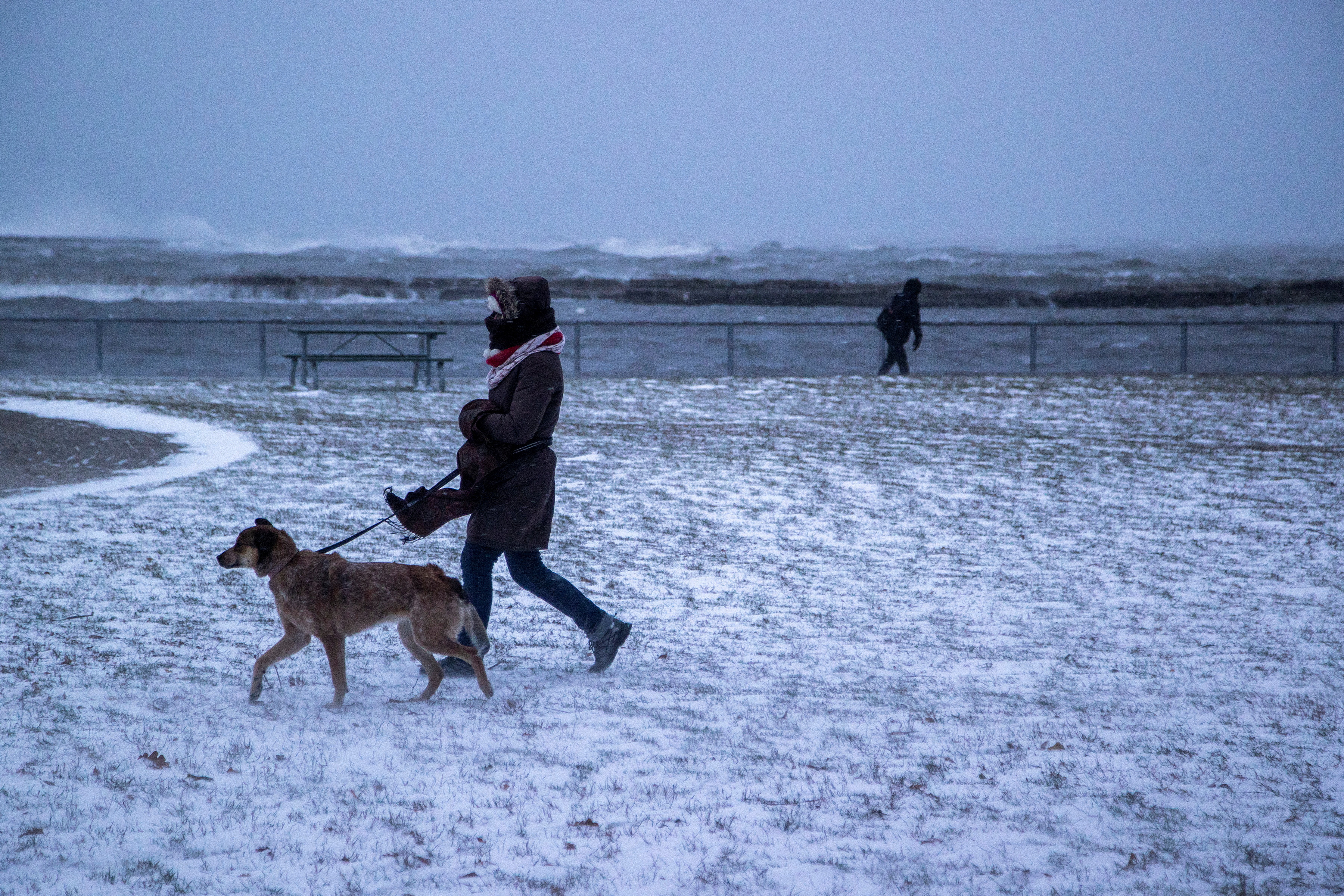 La gente camina junto al lago Ontario durante una tormenta de invierno en Toronto, Ontario, Canadá 23 de diciembre 2022 (REUTERS/Carlos Osorio)