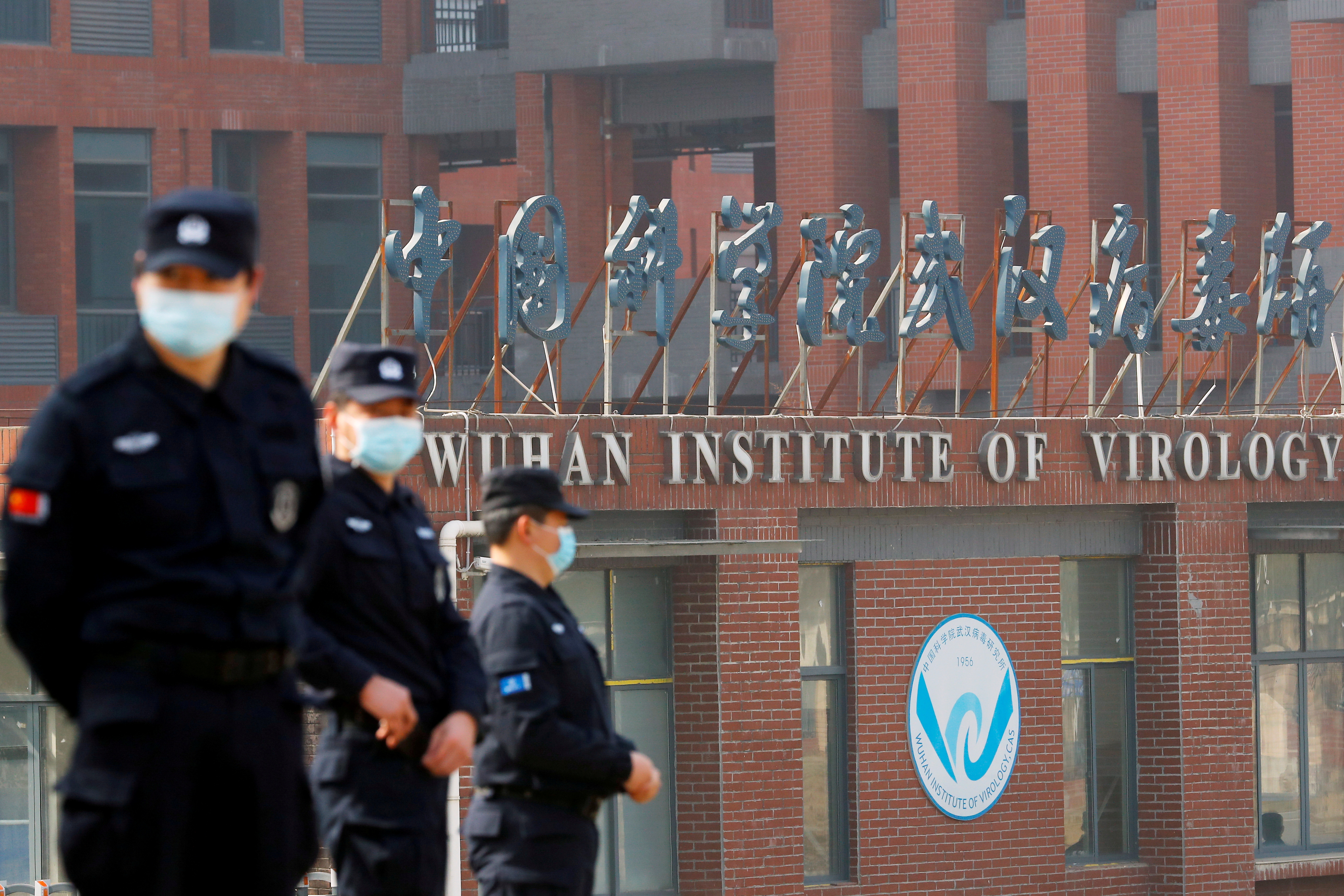 FILE PHOTO: Security personnel keep watch outside the Wuhan Institute of Virology during the visit by the World Health Organization (WHO) team tasked with investigating the origins of the coronavirus disease (COVID-19), in Wuhan, Hubei province, China February 3, 2021. REUTERS/Thomas Peter/File Photo