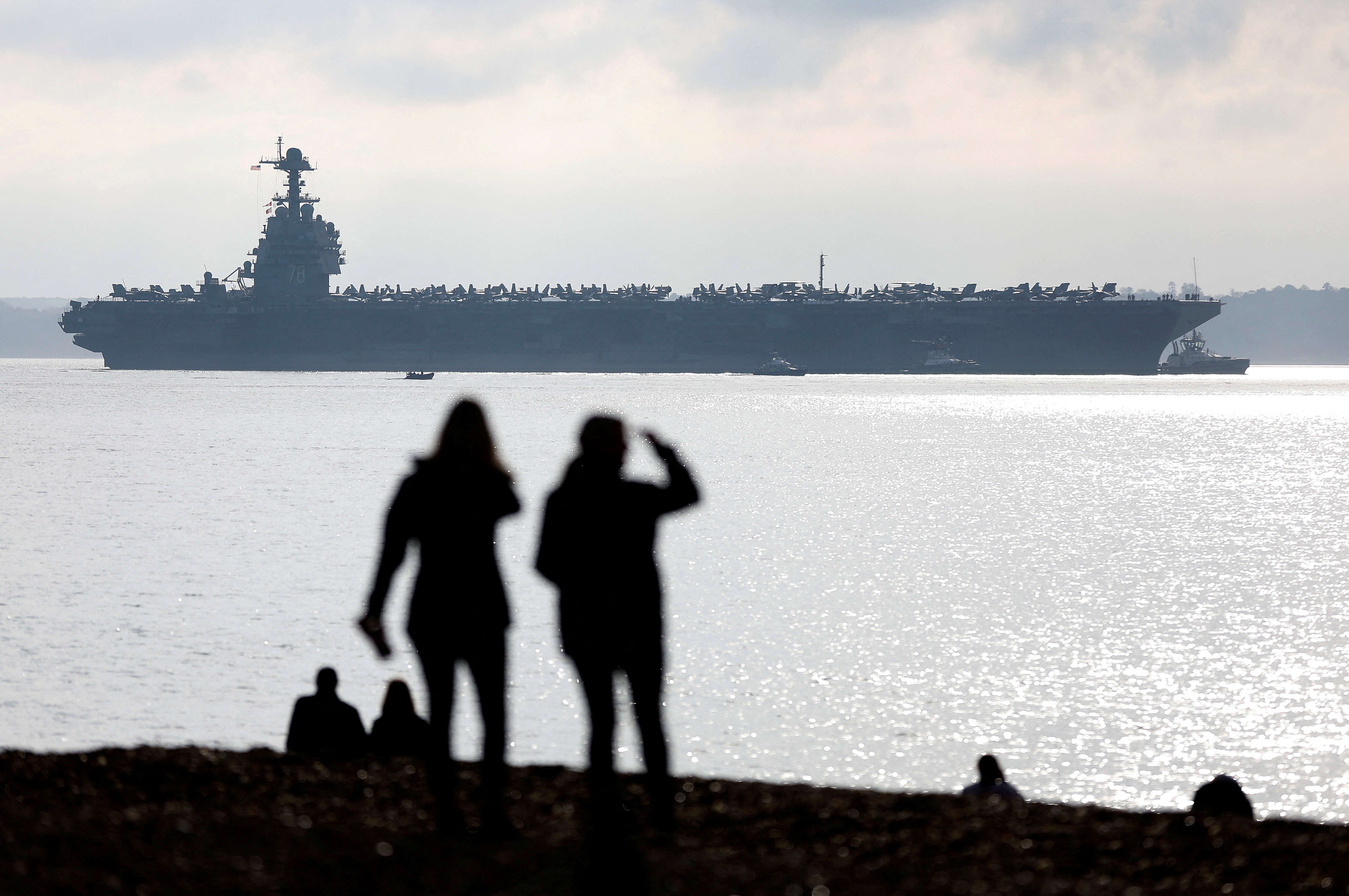 La gente observa desde una playa cercana cómo el portaaviones USS Gerald R Ford. REUTERS/Peter Nicholls IMÁGENES TPX DEL DÍA