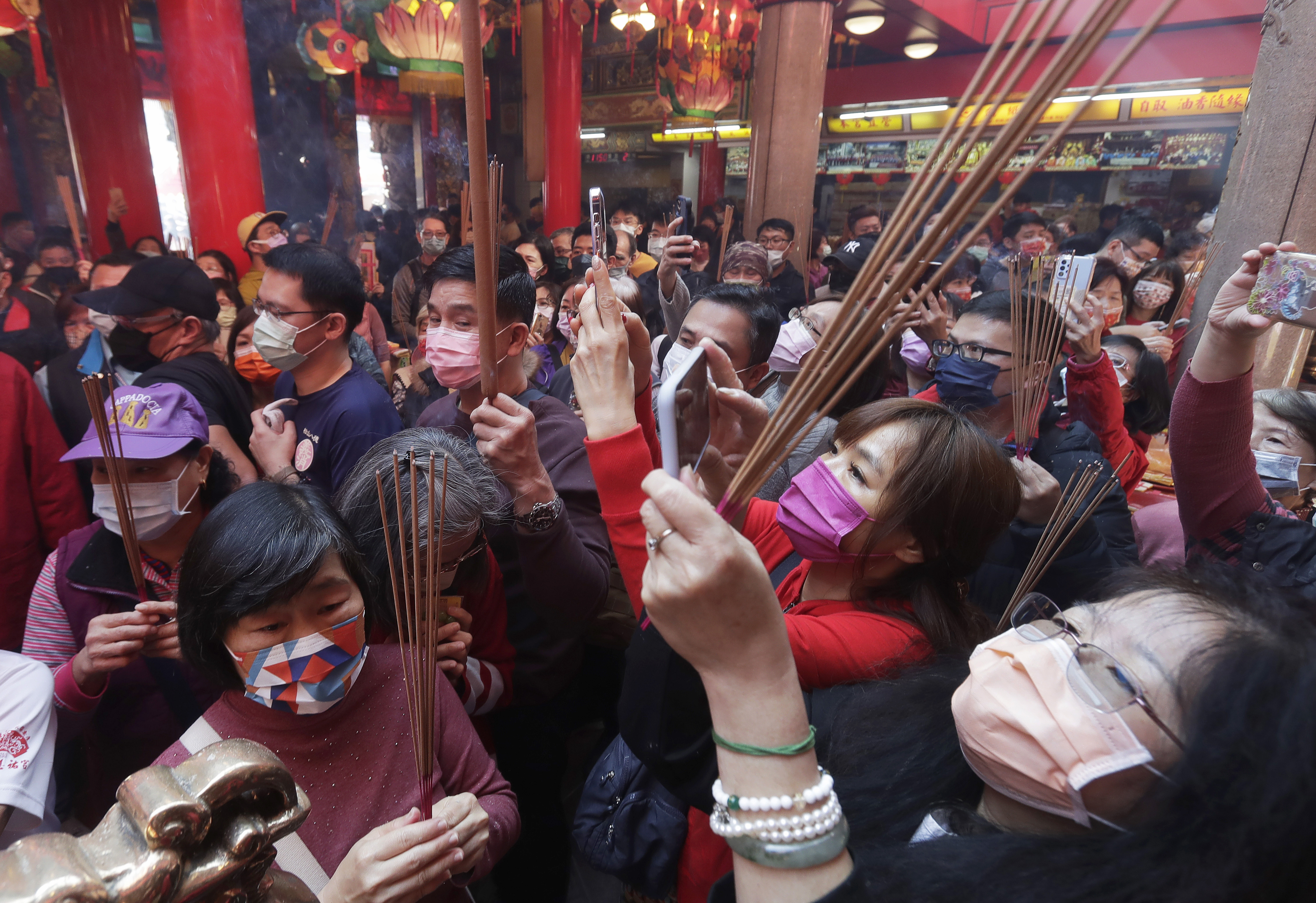 Worshipers wearing face masks to prevent the spread of the coronavirus pray at a temple on the first day of the Lunar New Year in Taipei, Taiwan, Sunday, Jan. 22, 2023. Each year is named after one of the 12 Chinese zodiac signs, in a cycle which is repeated, and the one that begins is the Year of the Rabbit.  (AP Photo/Chiang Ying-ying)