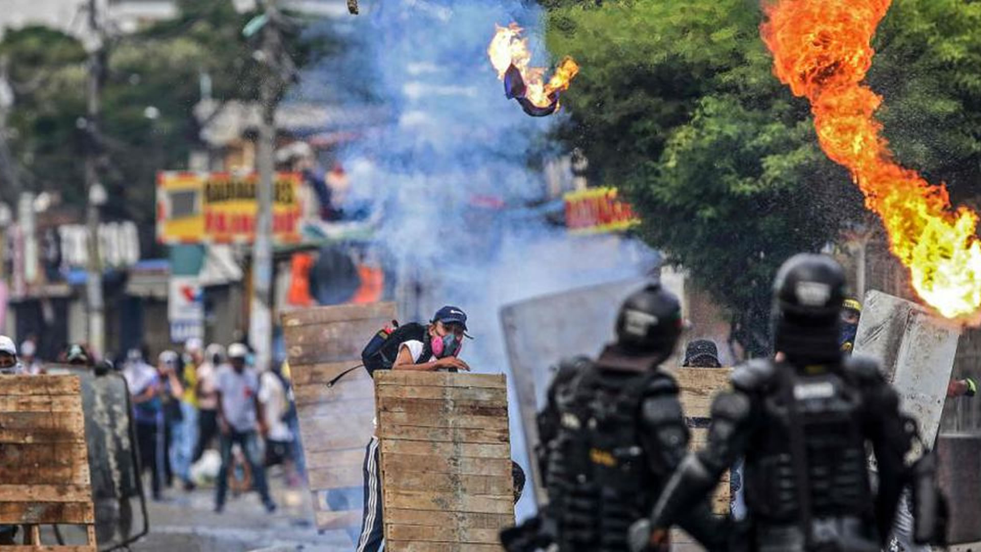 Manifestantes chocan con la policía antidisturbios durante una protesta contra un proyecto de reforma tributaria lanzado por el presidente colombiano Iván Duque, en Cali, Colombia. (AFP / Paola MAFLA)