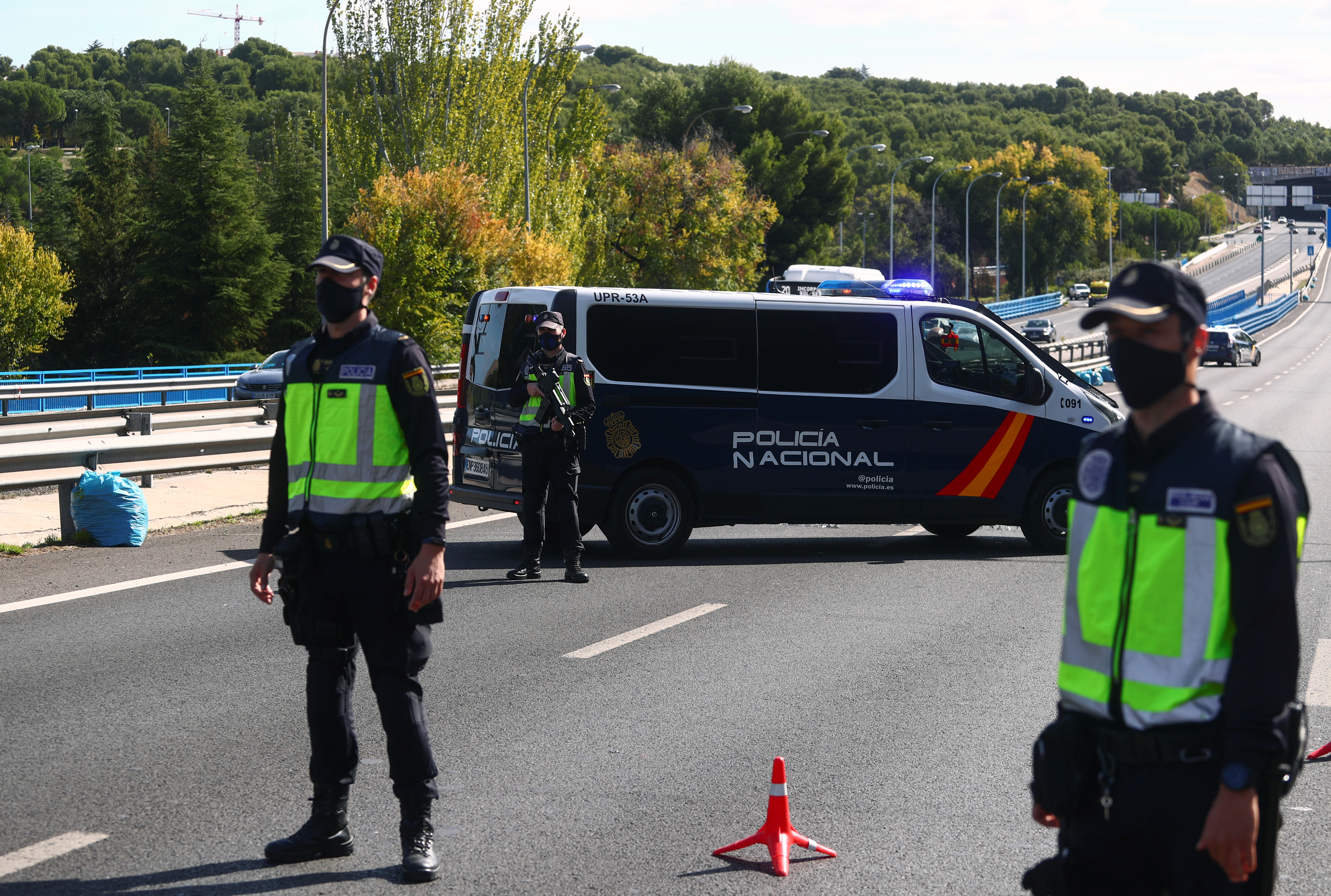 Oficiales de la Policía Nacional visten mascarillas protectoras en un puesto de control de tránsito en las afueras de Madrid (REUTERS/Sergio Perez)