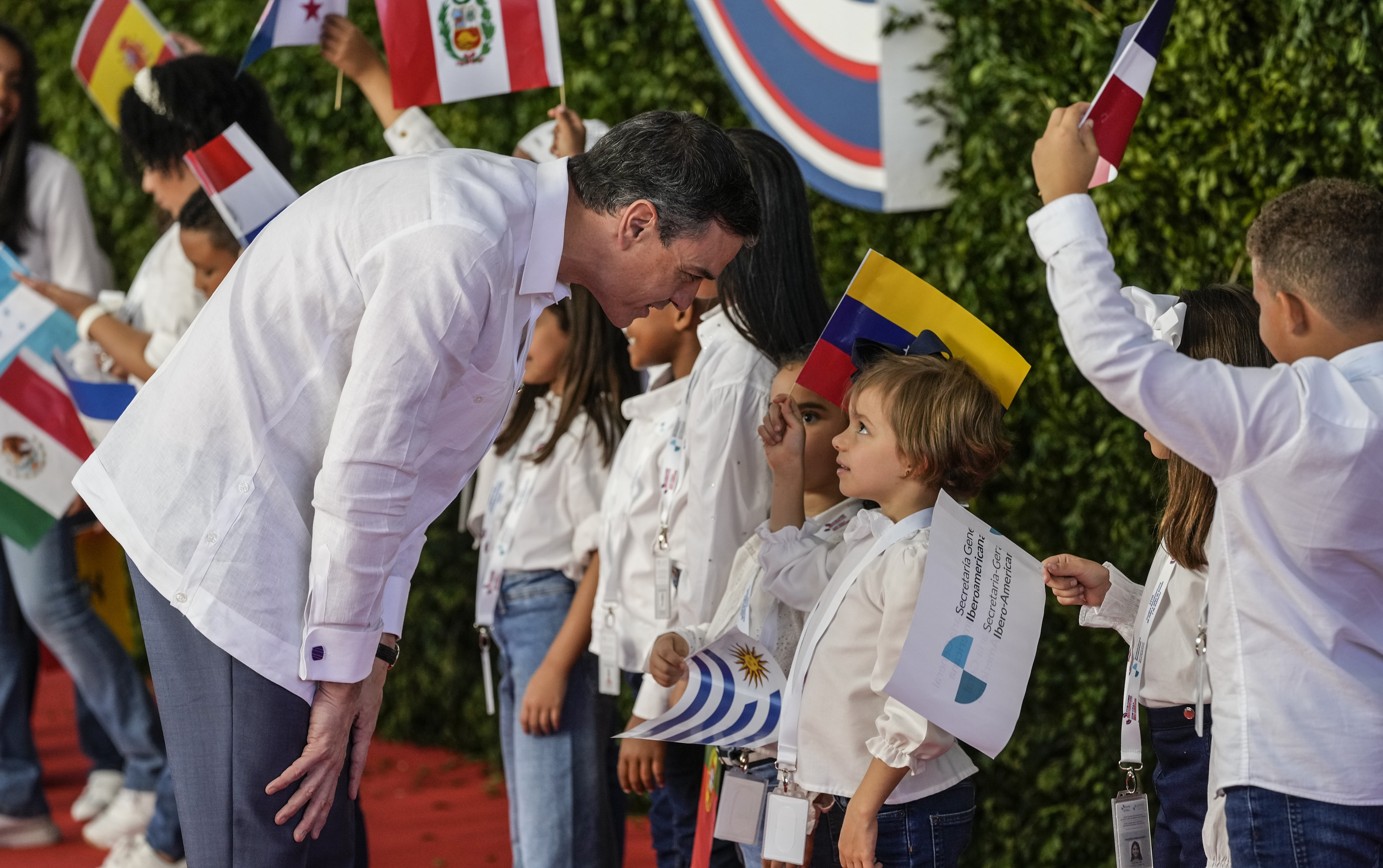 El presidente del gobierno español Pedro Sánchez habla con los niños a su llegada a la sesión de la 28ª Cumbre Iberoamericana, en Santo Domingo, República Dominicana, el sábado 25 de marzo de 2022. (Foto AP/Ariana Cubillos)