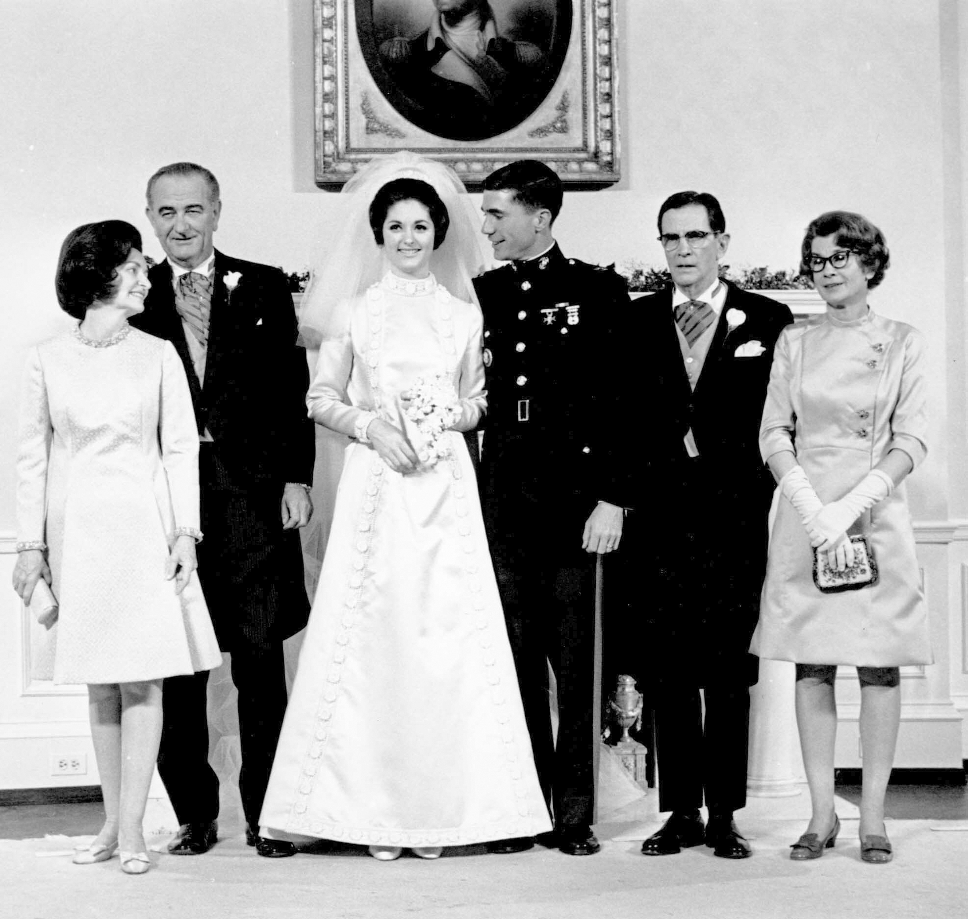 Los recién casados Capitán del Cuerpo de Marines Charles S. Robb y Lynda Bird Johnson, en el centro, posan para una foto con sus padres en el Salón Oval Amarillo de la Casa Blanca en Washington el 9 de diciembre de 1967. De pie, de izquierda a derecha, la primera dama Lady Bird Johnson, el presidente Lyndon B. Johnson, el novio, James S. Robb y Frances Robb (AP)