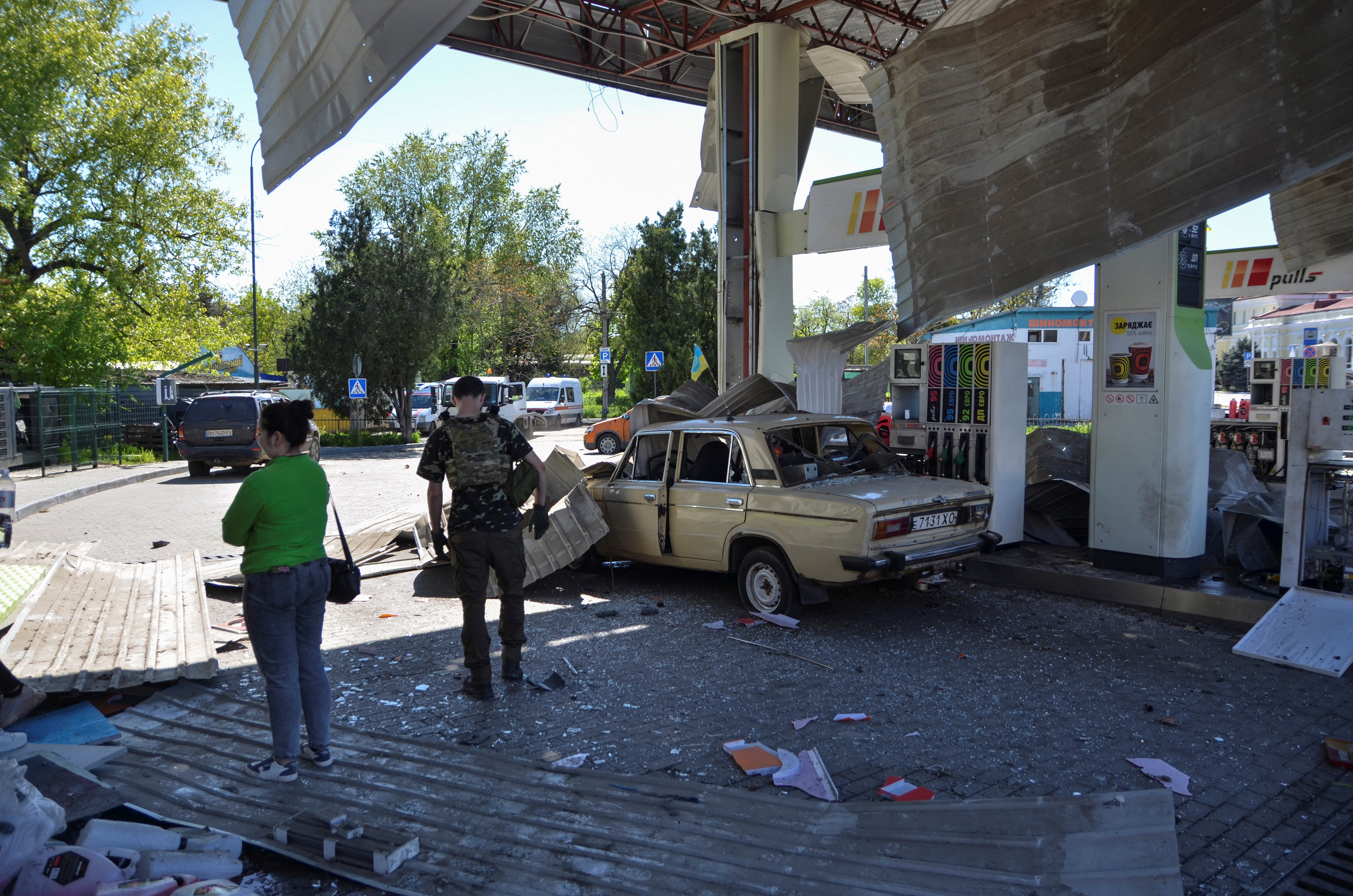 Gente en una gasolinera dañada por un ataque militar ruso, en medio del ataque de Rusia a Ucrania, en Kherson, Ucrania 3 de mayo 2023. REUTERS/Ivan Antypenko