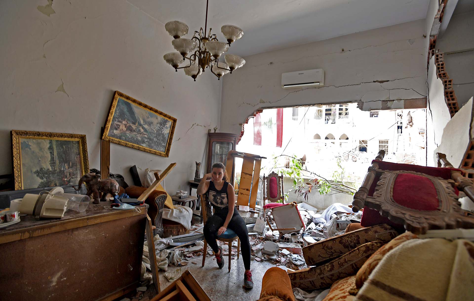 Una mujer observa los escombros de su apartamento en Beirut dañado por la explosión en el puerto.