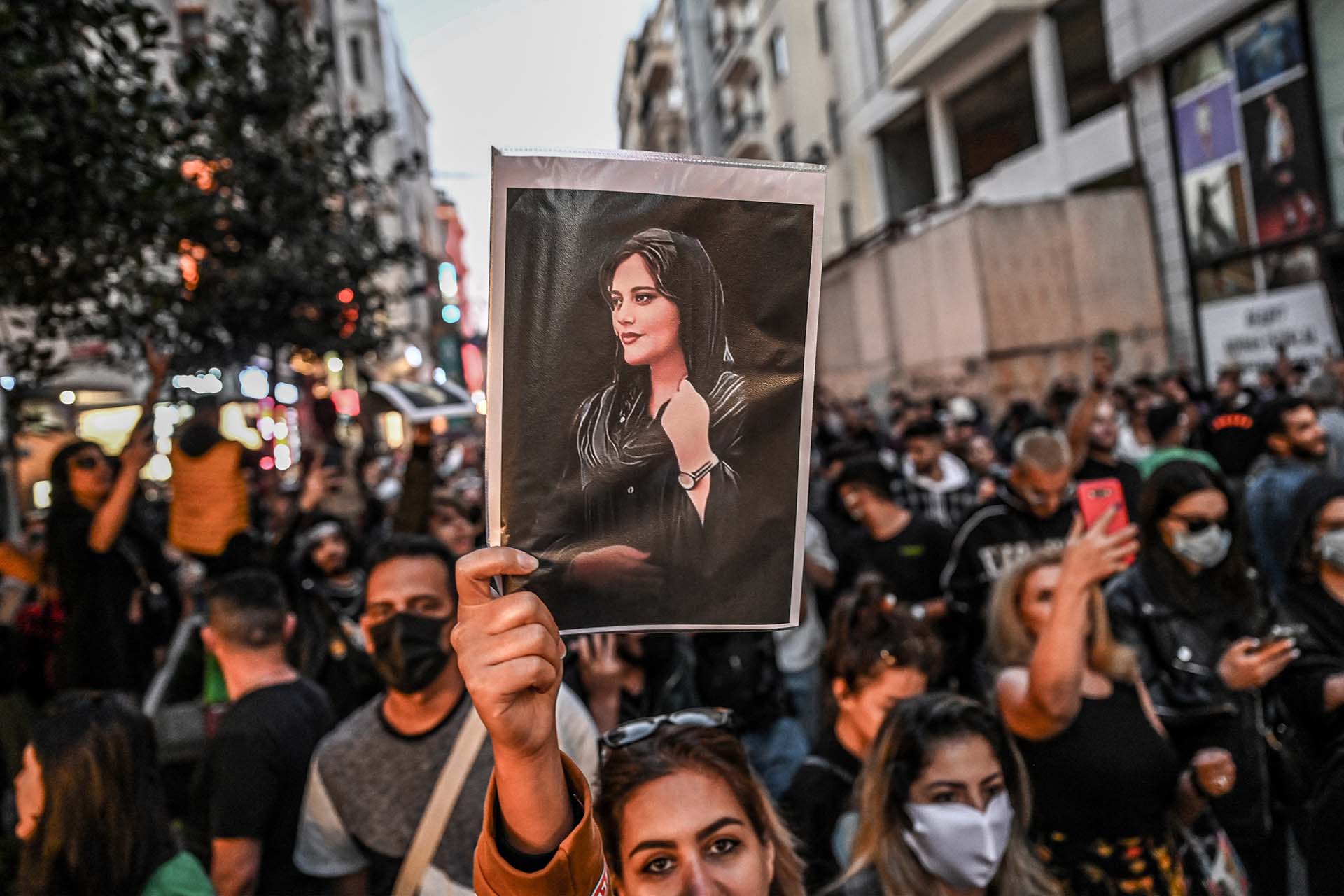Un manifestante sostiene un retrato de Mahsa Amini durante una manifestación en apoyo de Amini, que murió tras ser detenida en Teherán por la policía de la moral de la República Islámica, en la avenida Istiklal de Estambul el 20 de septiembre de 2022. (Foto de Ozan KOSE/AFP)