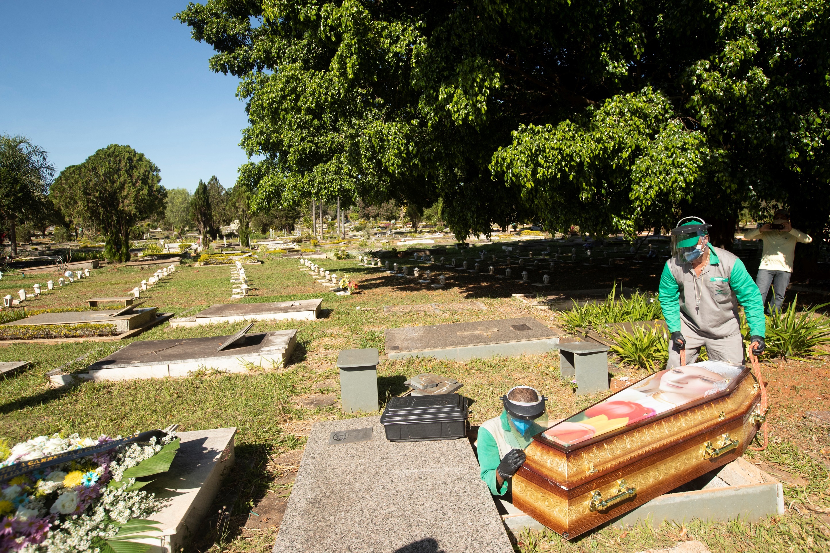 Trabajadores del cementerio Campo de Esperanza entierran una víctima de coronavirus. EFE/ Joédson Alves
