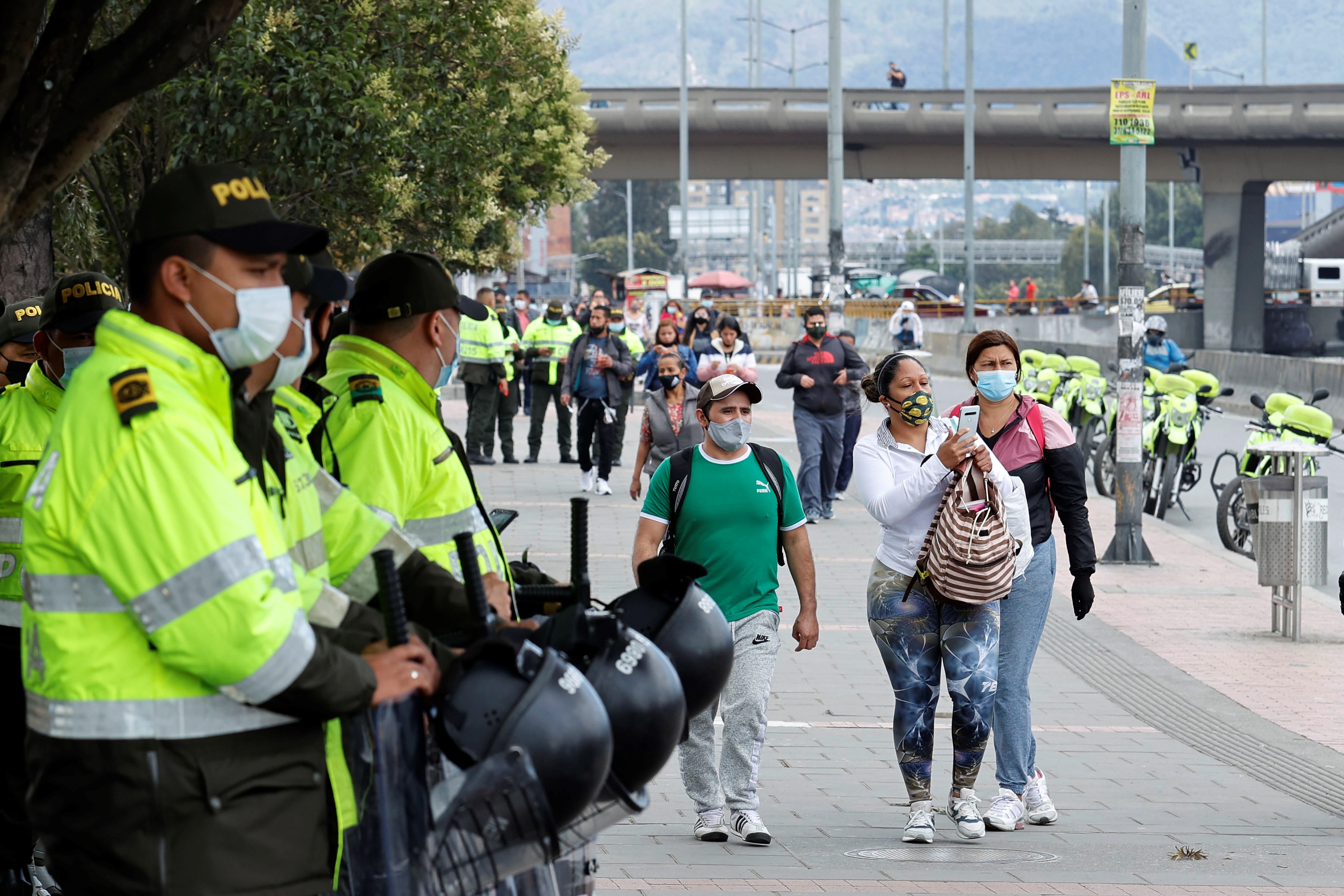 Integrantes de la Policía de Colombia vigilan en una vía bloqueada por comerciante como protesta por un nuevo confinamiento hoy, en el sector de Venecia en Bogotá (Colombia). EFE/Mauricio Dueñas Castañeda
