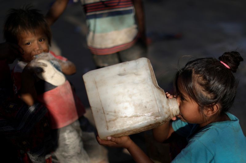 Niños de la comunidad indígena wichi beben agua desde bidones plásticos en la provincia de Salta (REUTERS/Ueslei Marcelino)