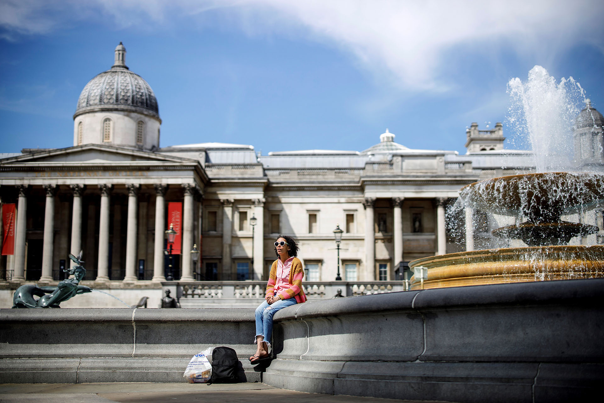 Una mujer disfruta del sol en la Trafalgar Square de Londres.